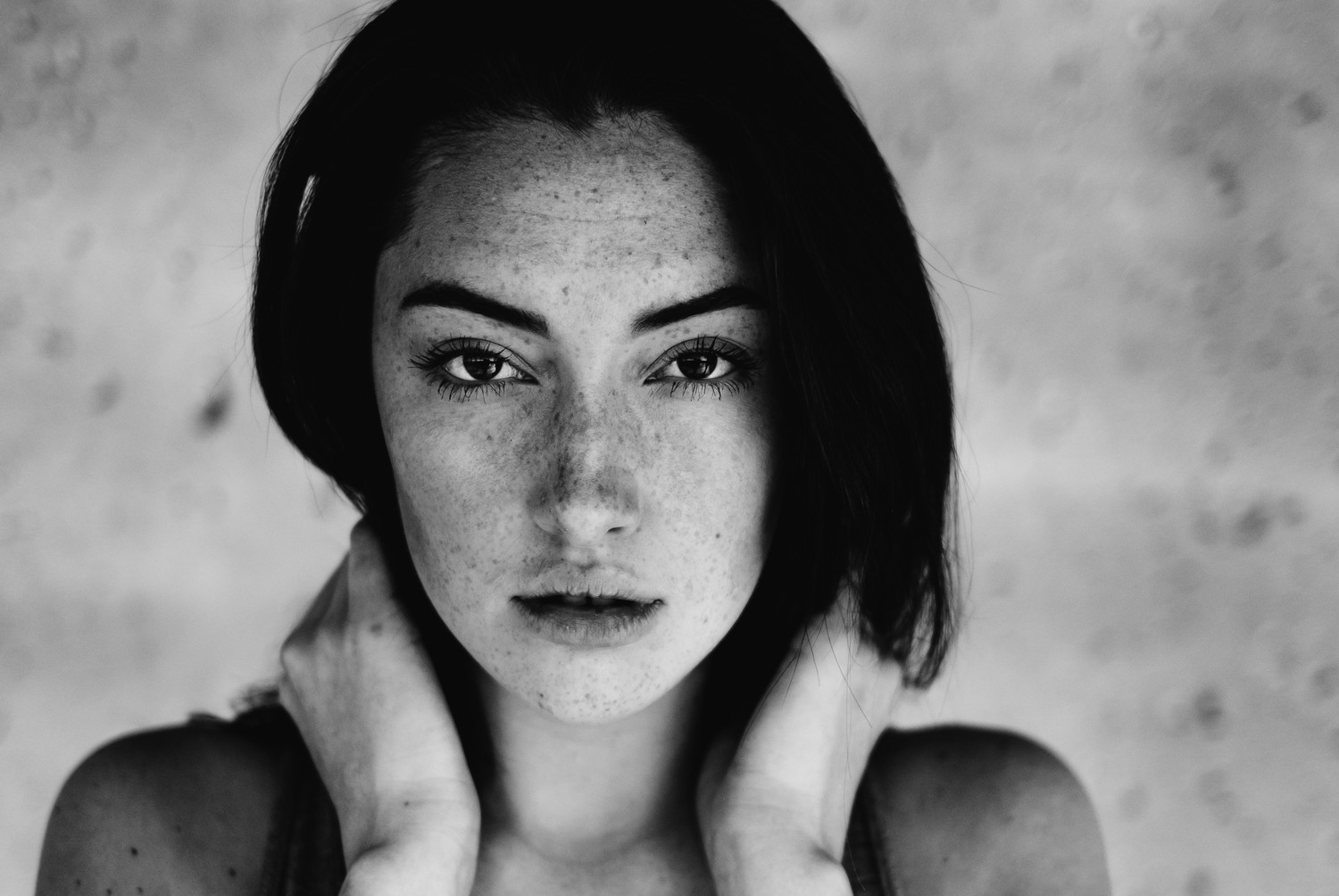 Monochrome portrait of a woman with freckles looking at viewer HD Wallpaper