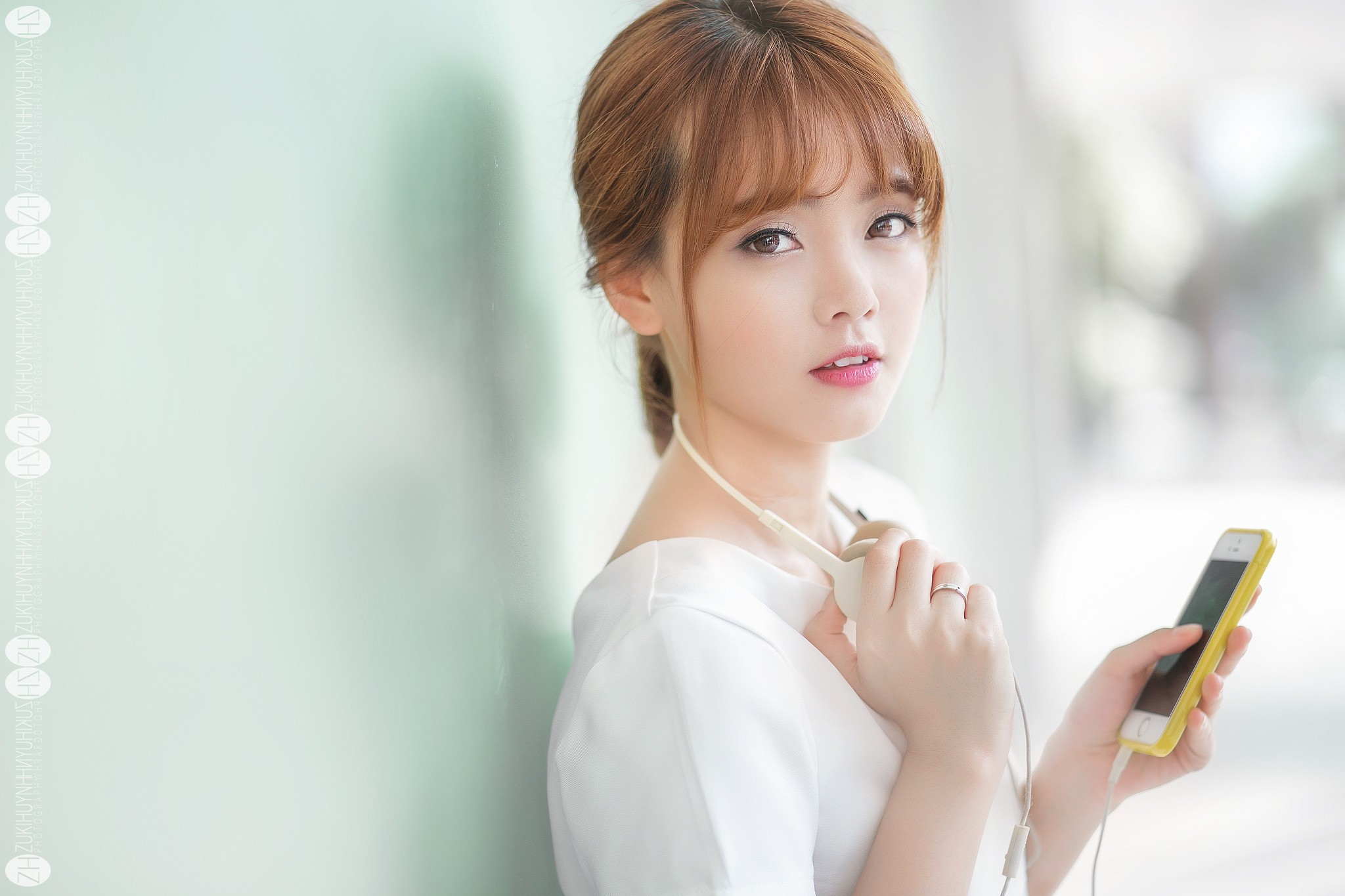 Asian woman with auburn hair holding a smartphone HD Wallpaper
