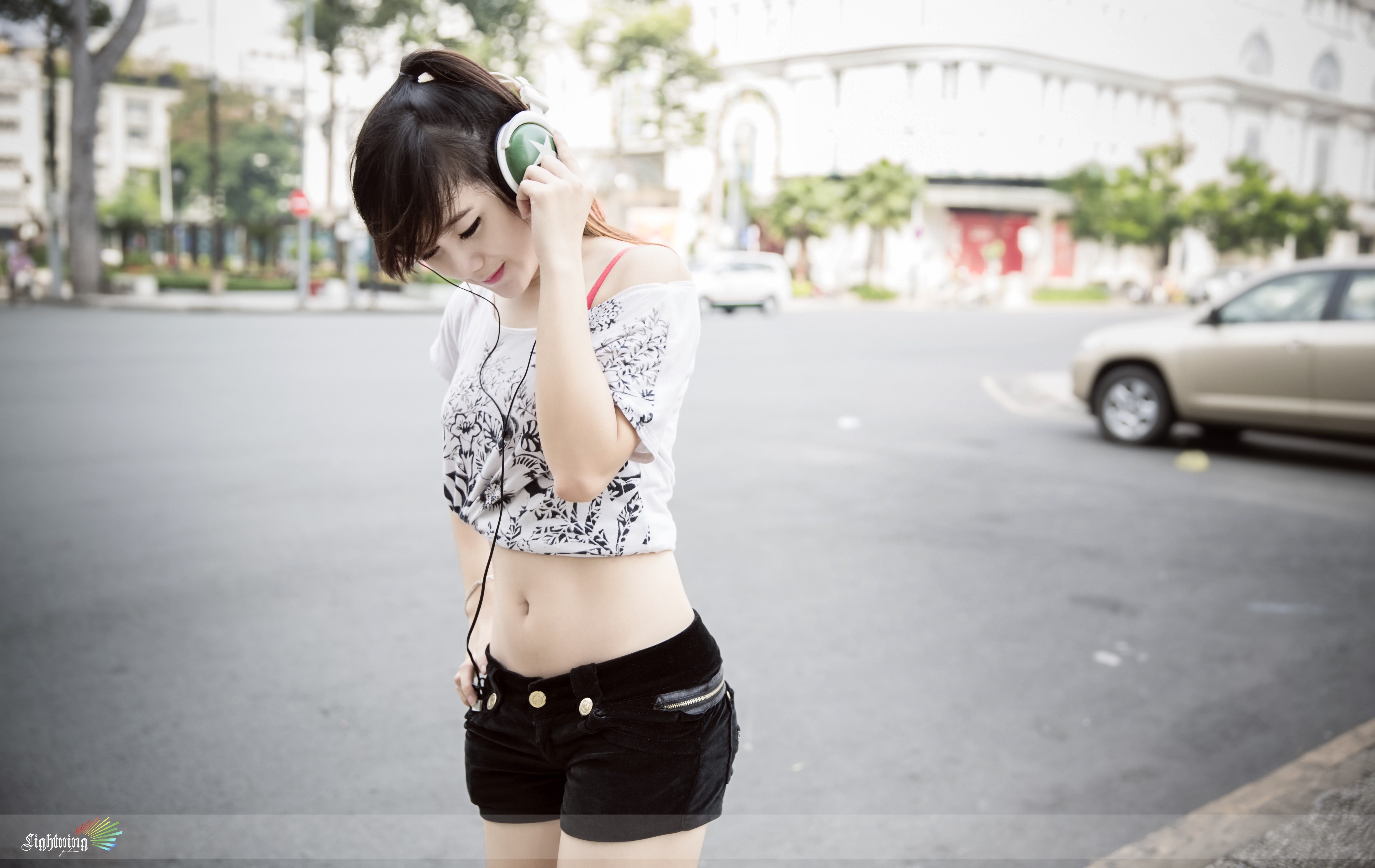 Asian woman with headphones listening to music outdoors HD Wallpaper
