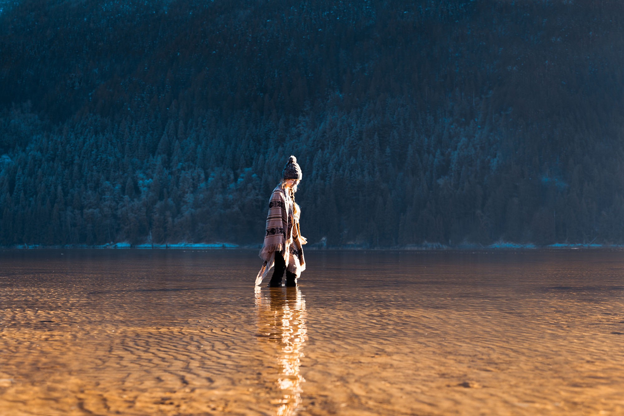Woman in hat and poncho standing in a lake HD Wallpaper