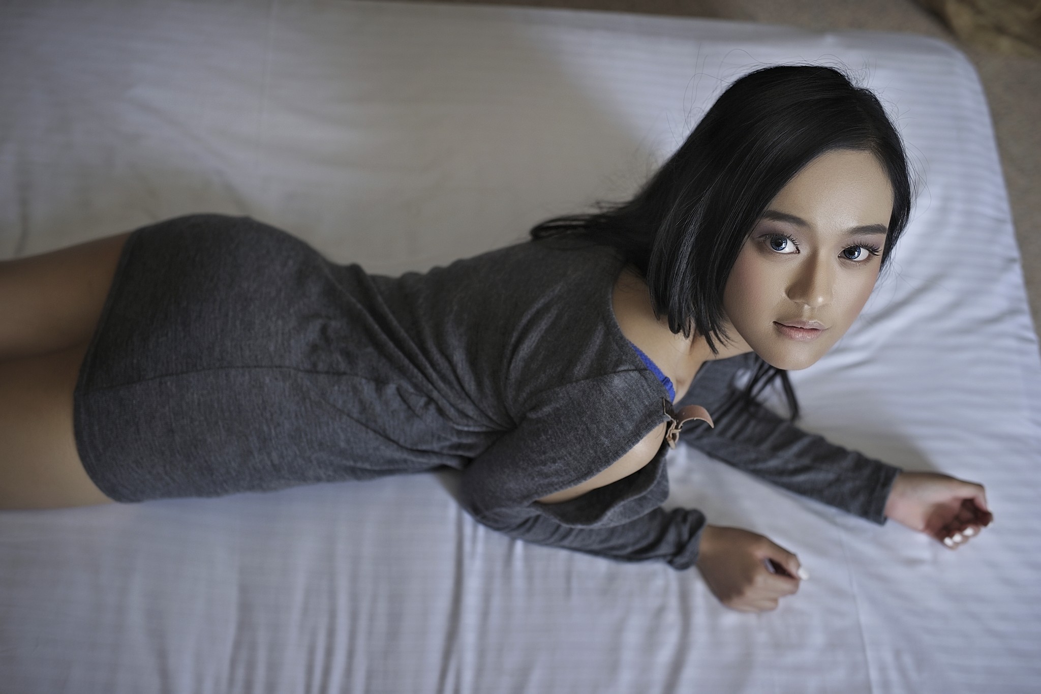 Asian woman lying on a bed HD Wallpaper