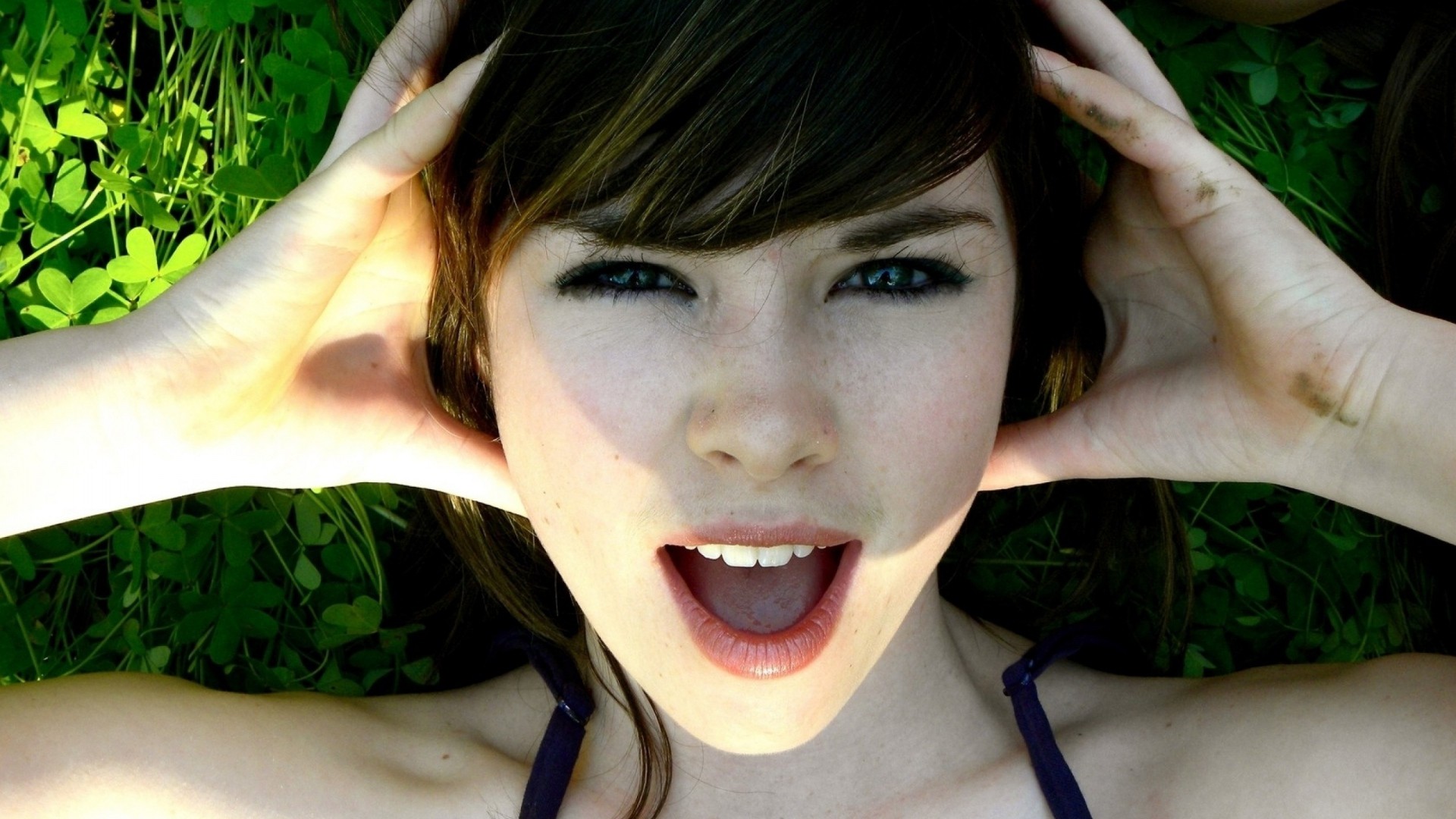 Woman lying on grass with hands on head HD Wallpaper