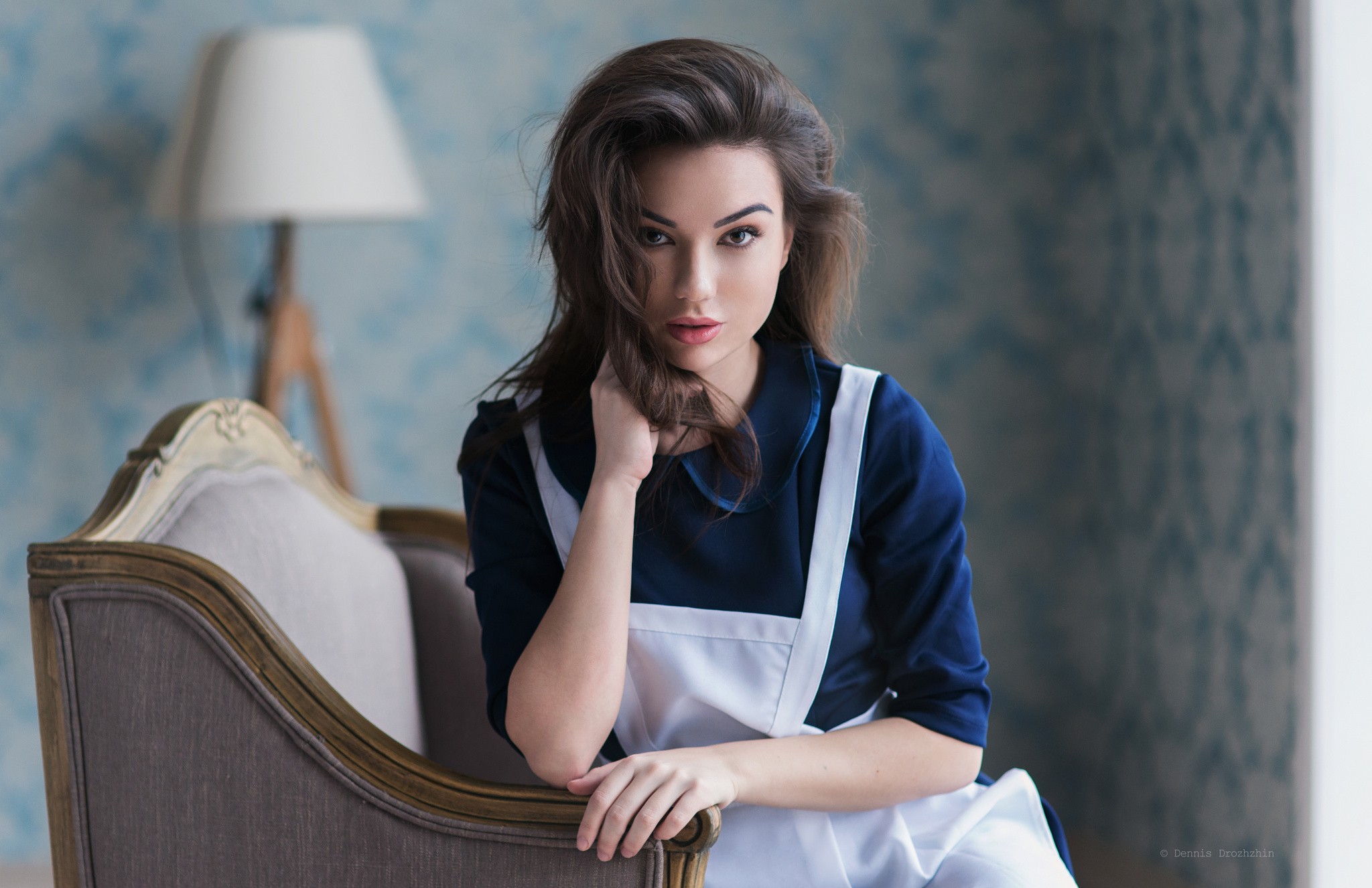 Woman in blue dress and white apron sitting on a couch HD Wallpaper