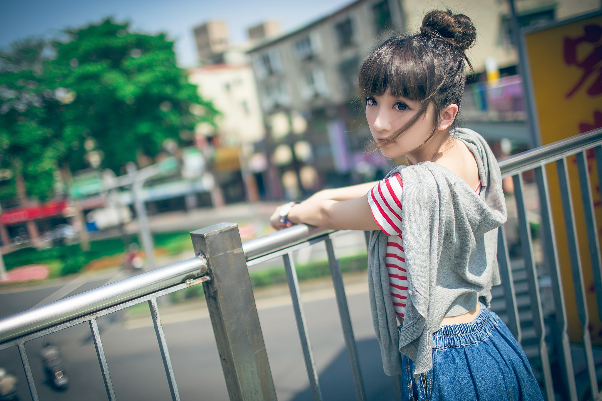 Asian woman with hair bun leaning on railing HD Wallpaper