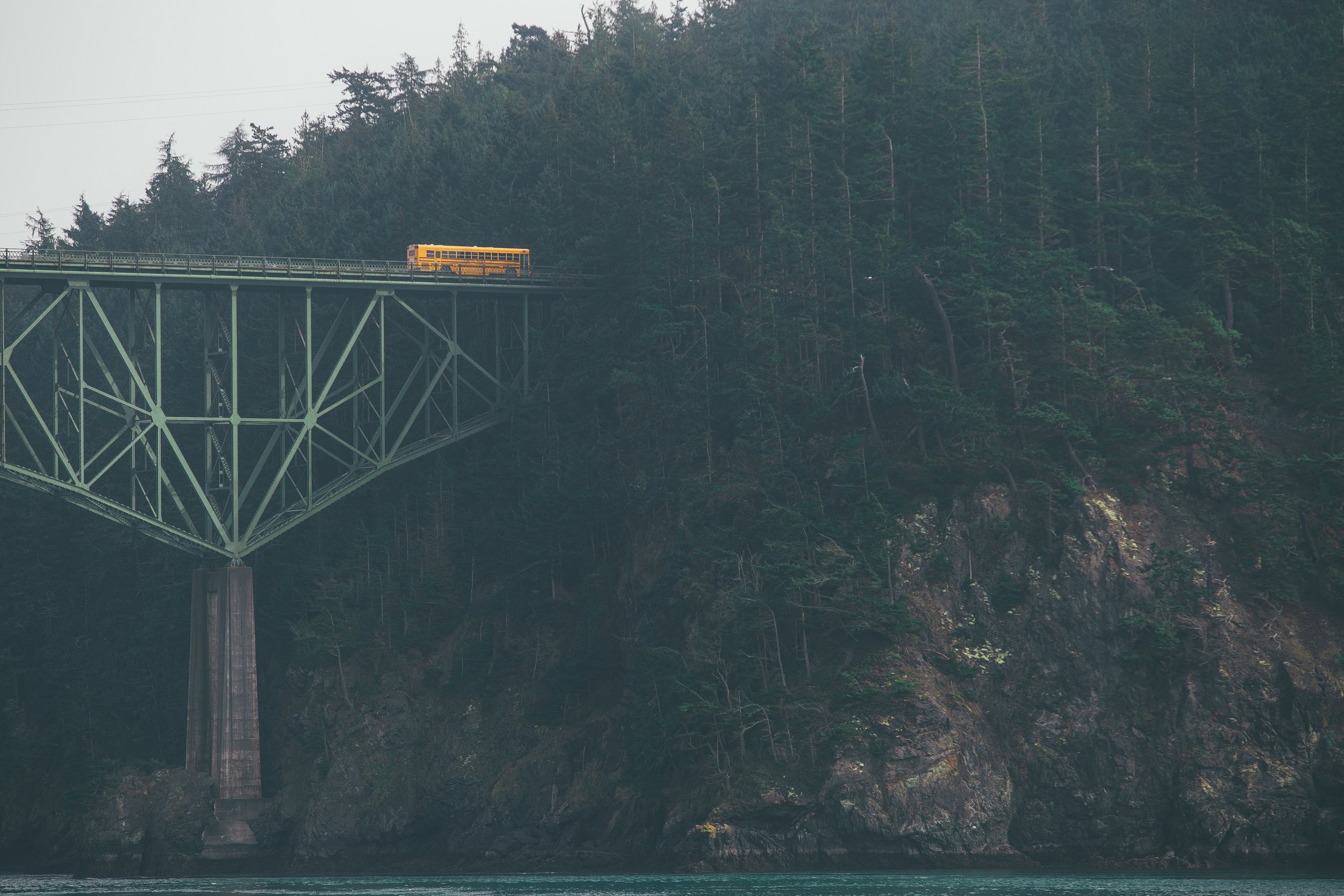 Yellow school bus on a bridge over water HD Wallpaper