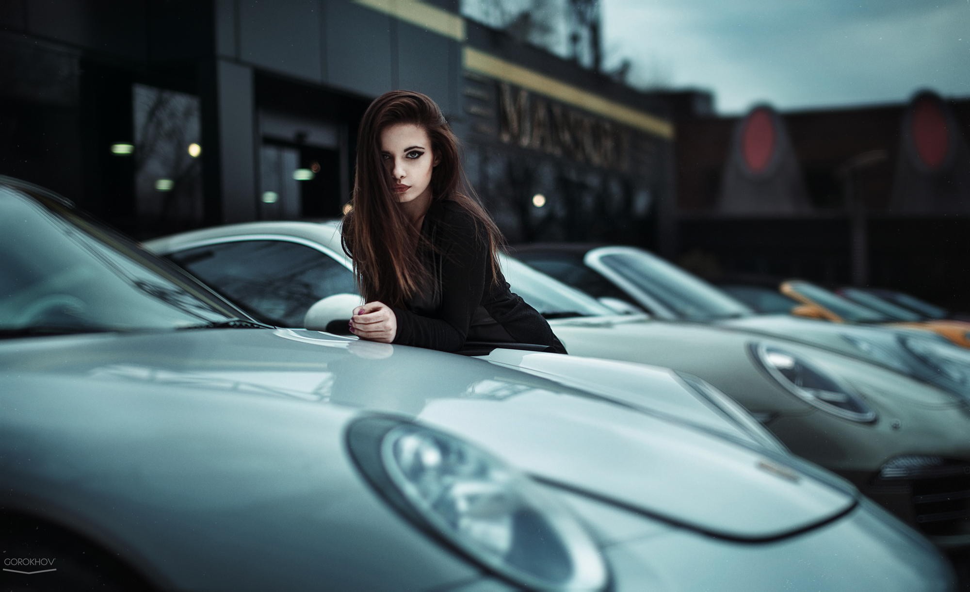 Brunette model leaning on a Porsche car HD Wallpaper