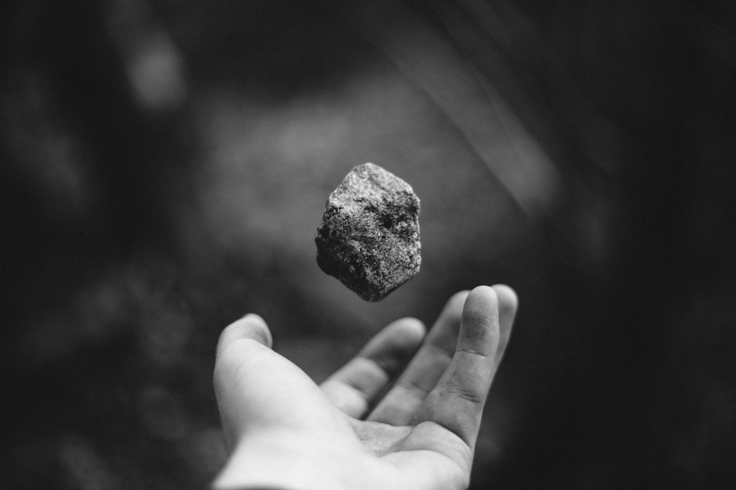 A hand levitates a rock in monochrome HD Wallpaper