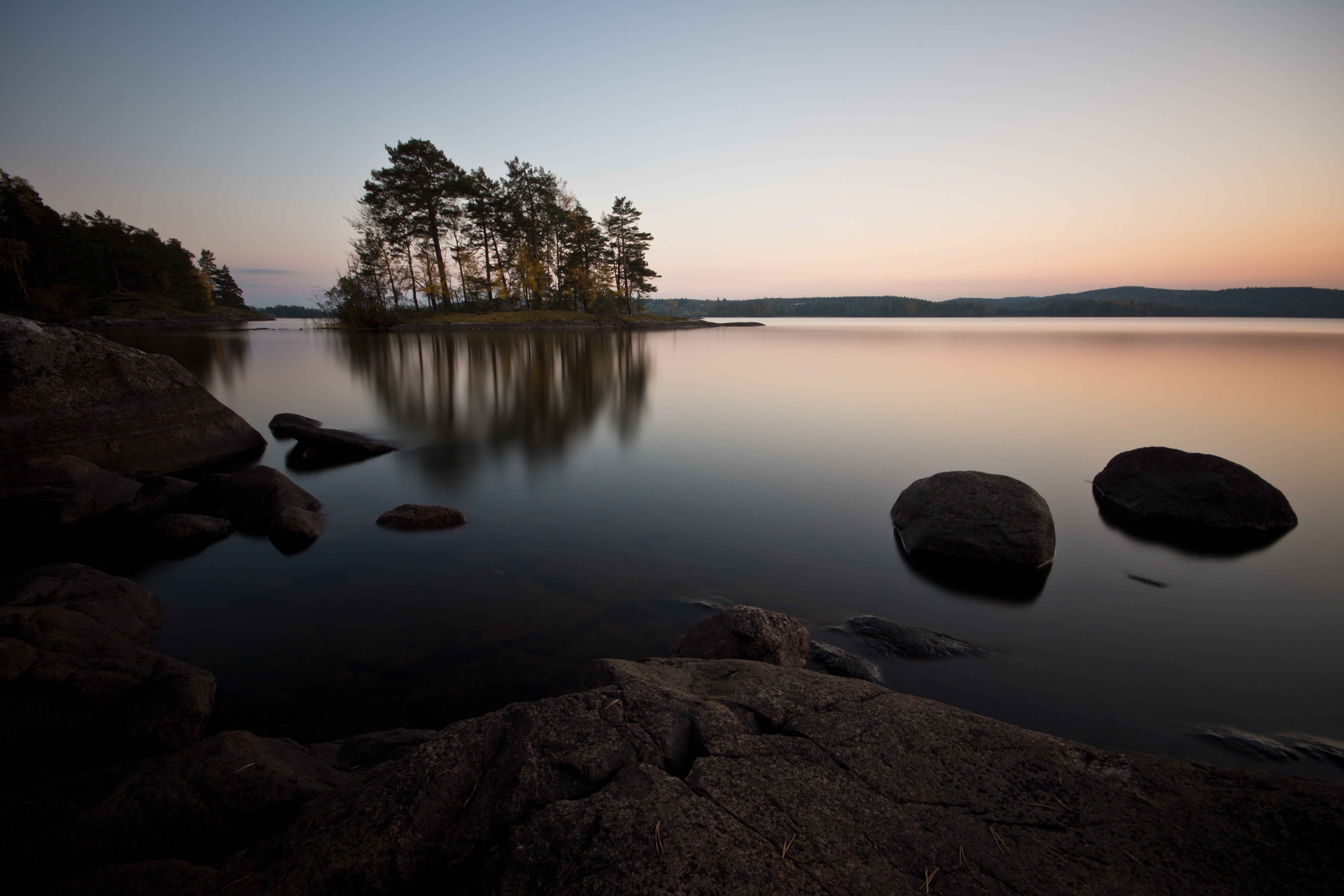 Calm lake with island and rocks at sunset HD Wallpaper