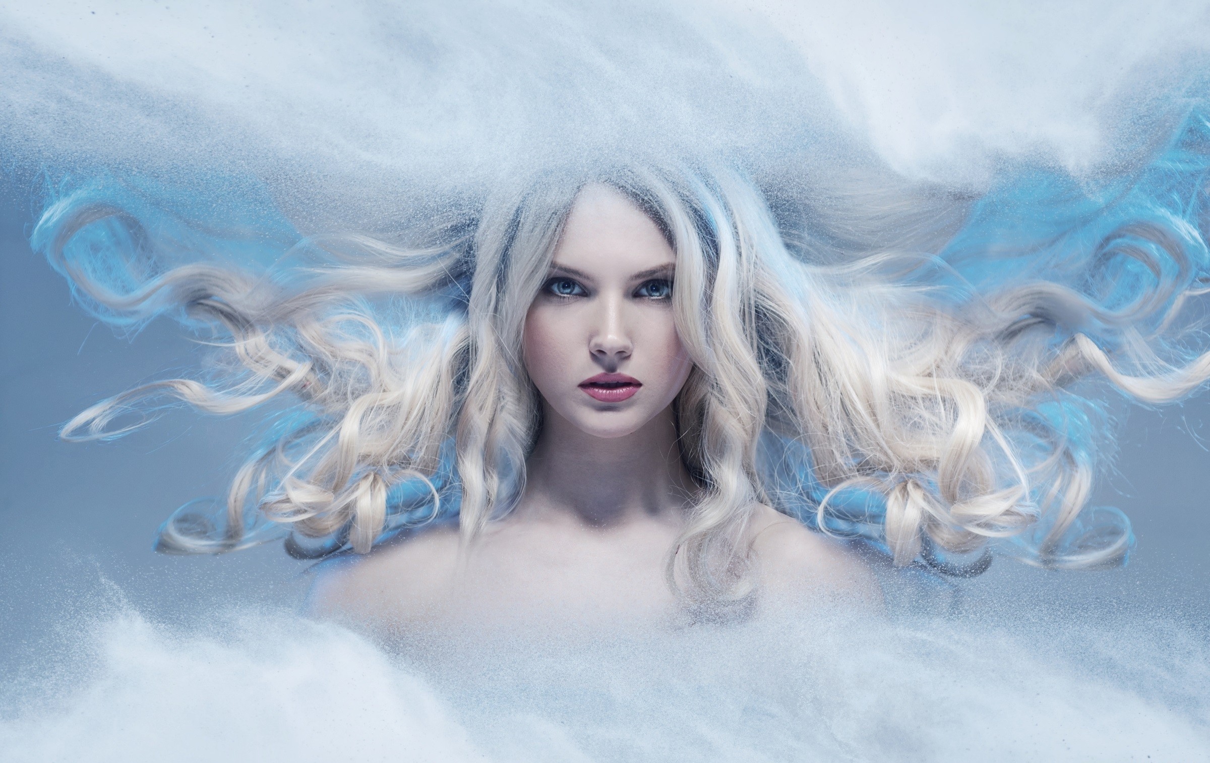 Woman with flowing blonde hair and blue powder HD Wallpaper