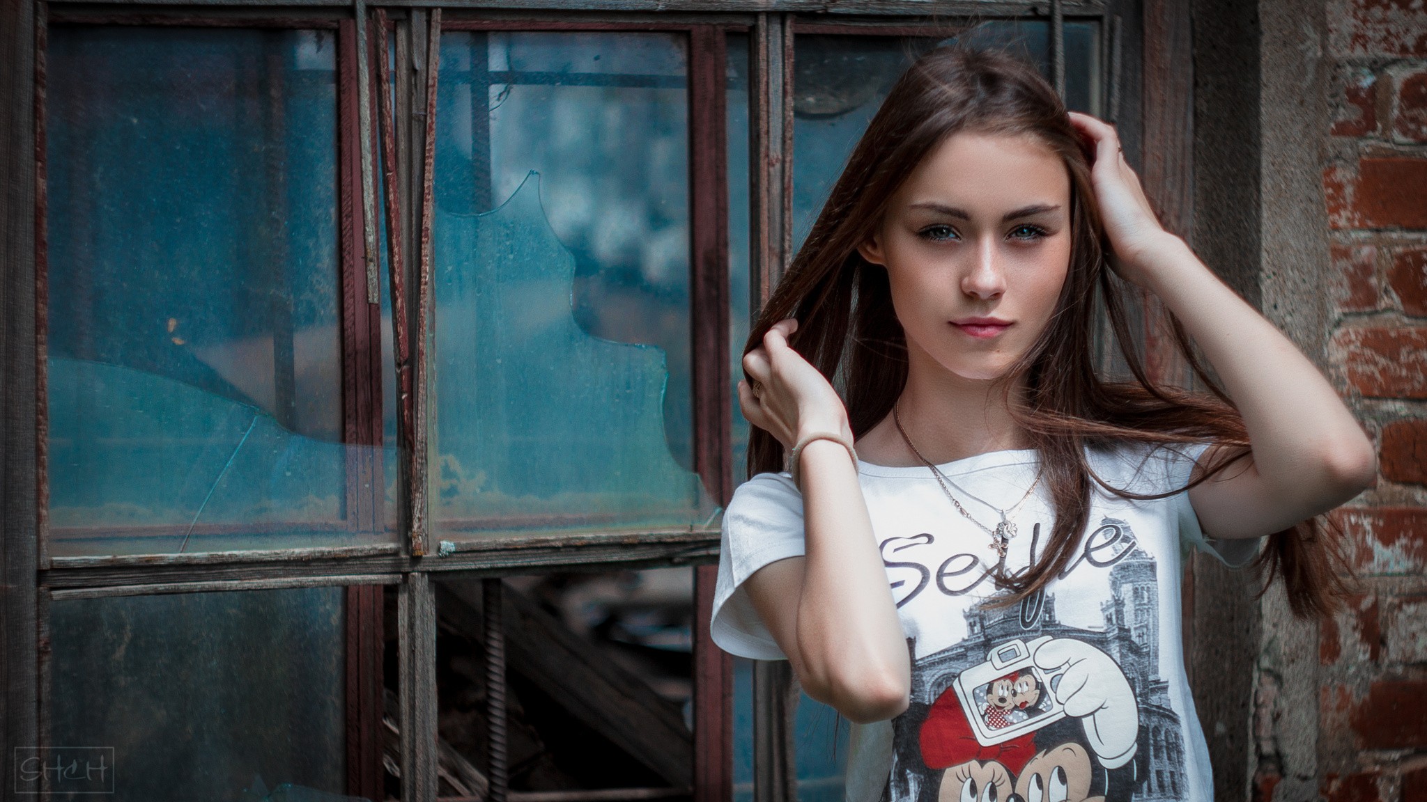 Woman with hands on head in front of broken window HD Wallpaper