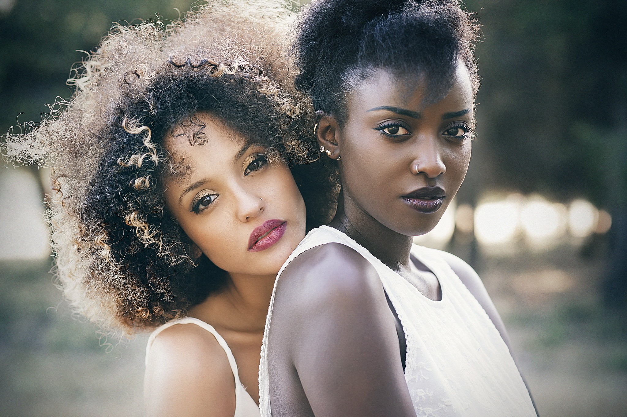 Two women with piercings and curly hair HD Wallpaper