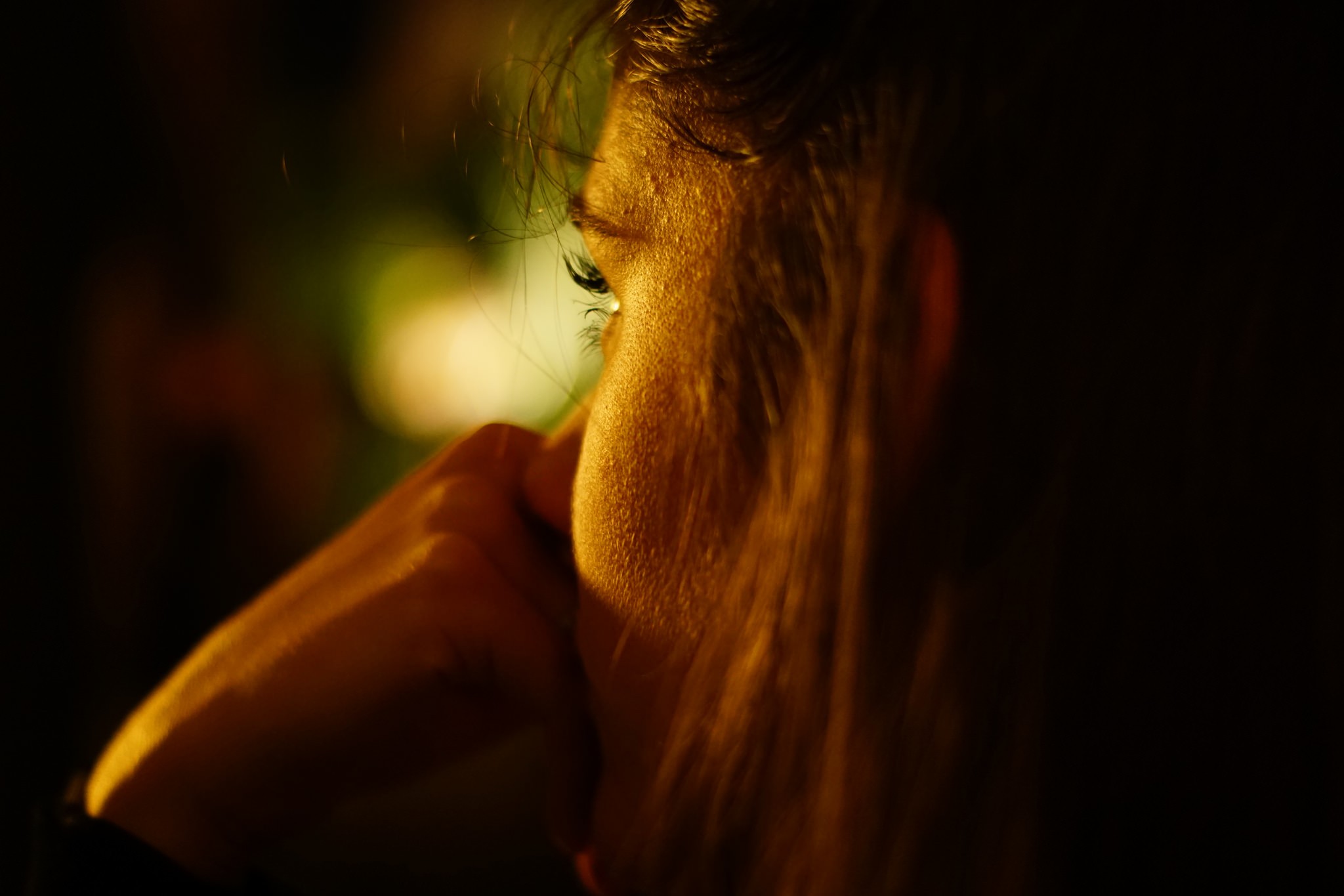 Woman with hand on chin in golden light HD Wallpaper