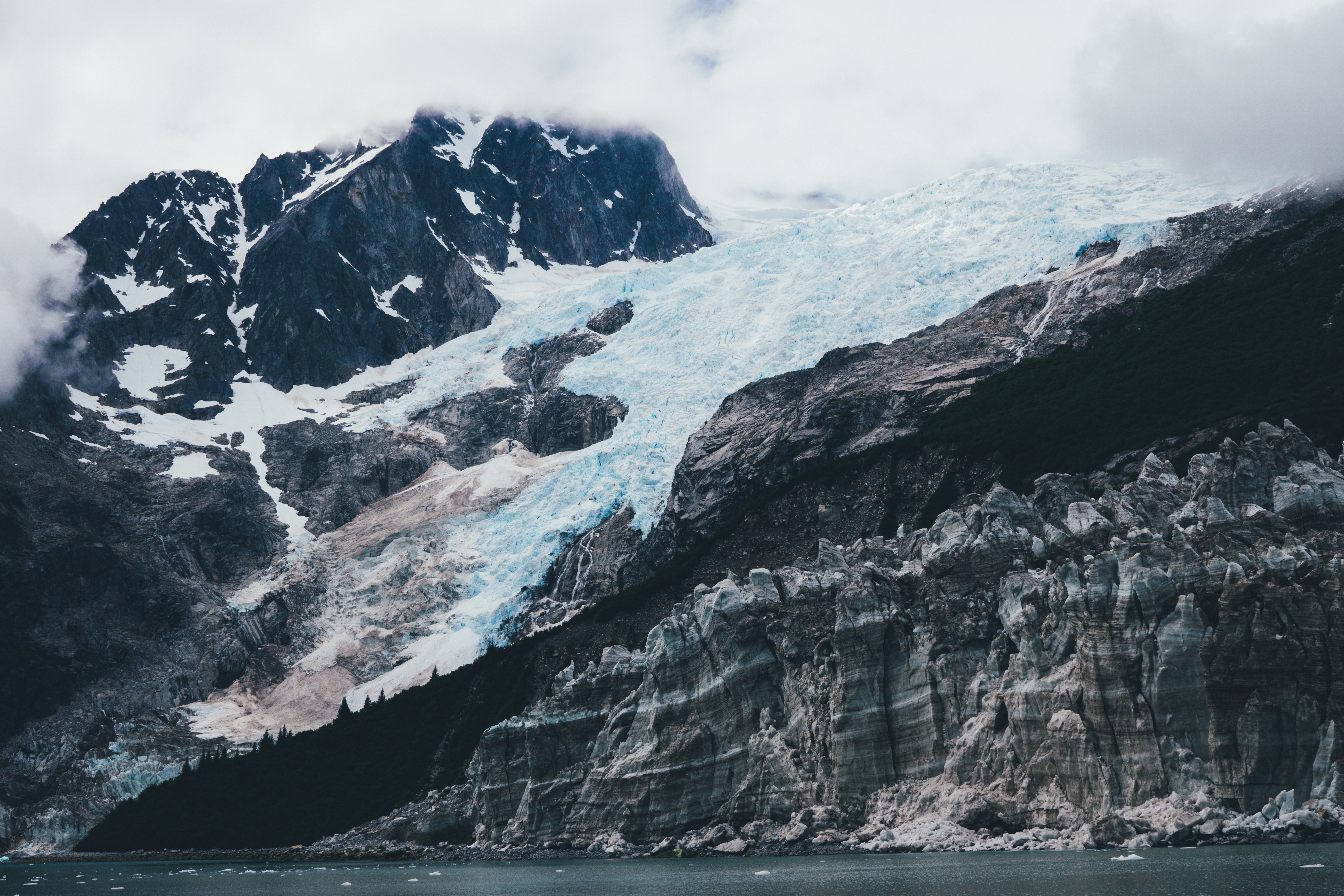 Glacier on a mountain with clouds and water HD Wallpaper