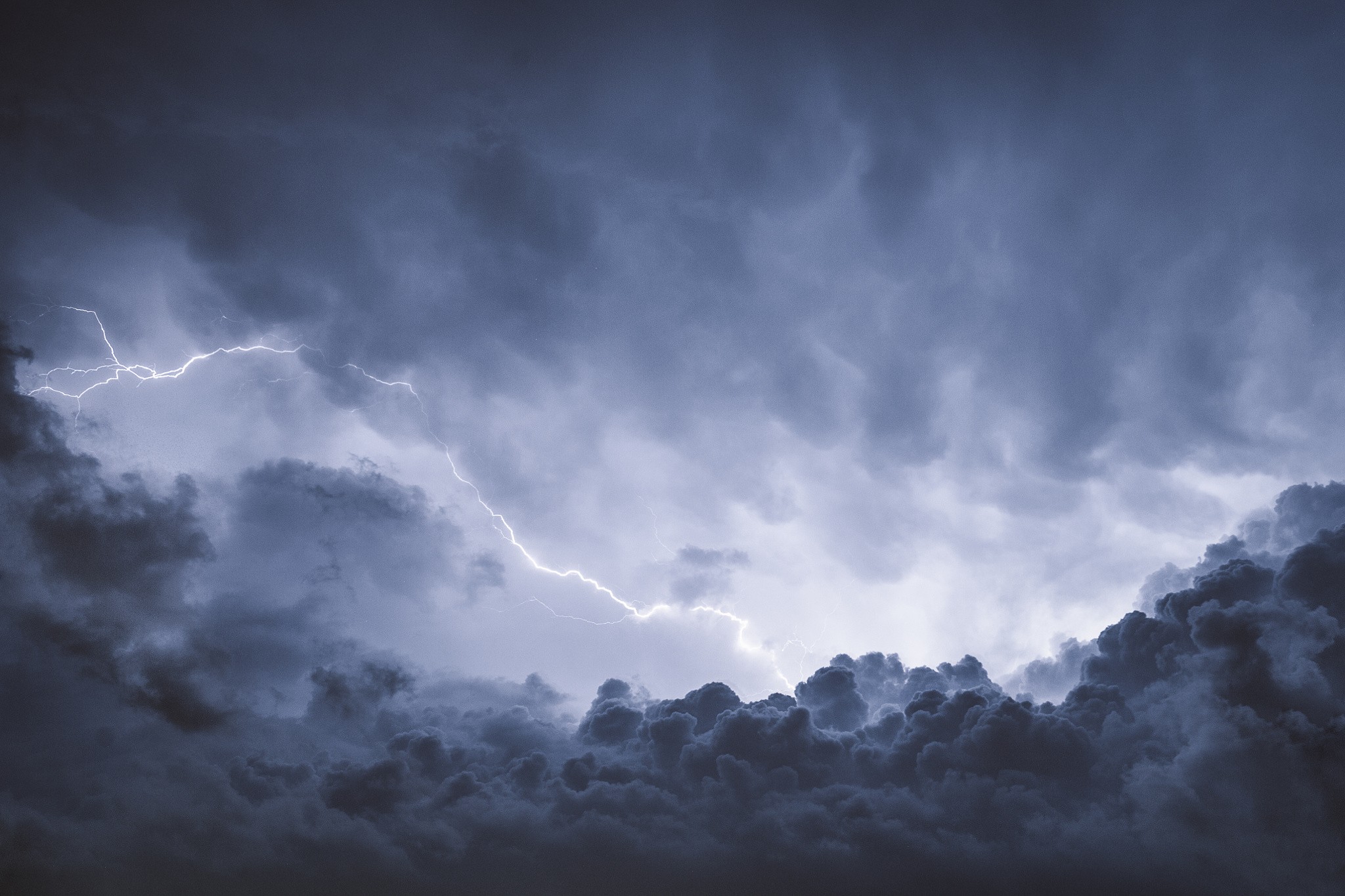 Lightning strikes through dark storm clouds in the sky HD Wallpaper
