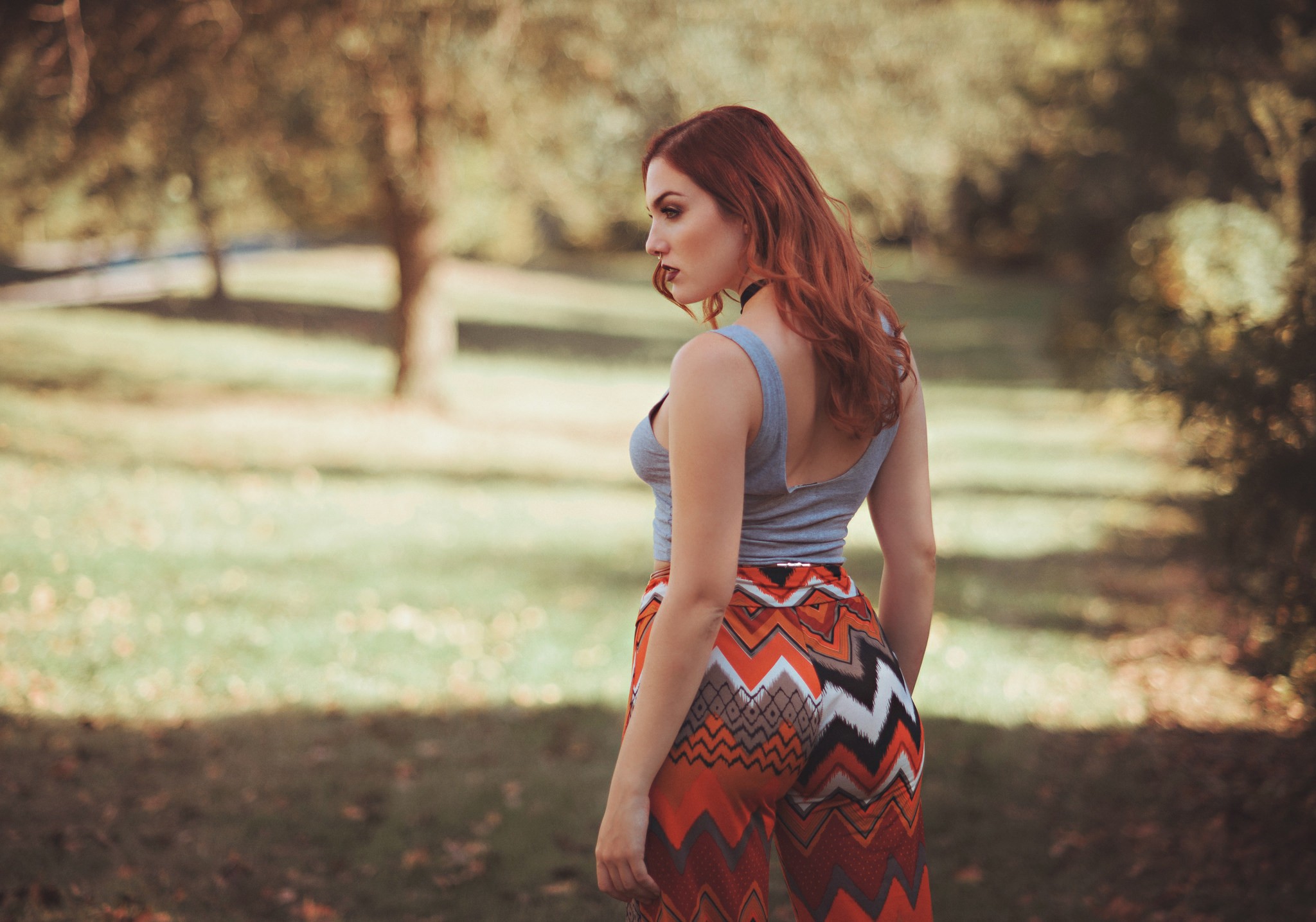 Redhead woman in patterned pants in a park HD Wallpaper