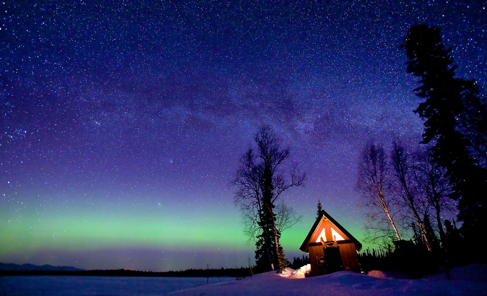 Aurora Borealis over a snowy landscape with a cabin HD Wallpaper