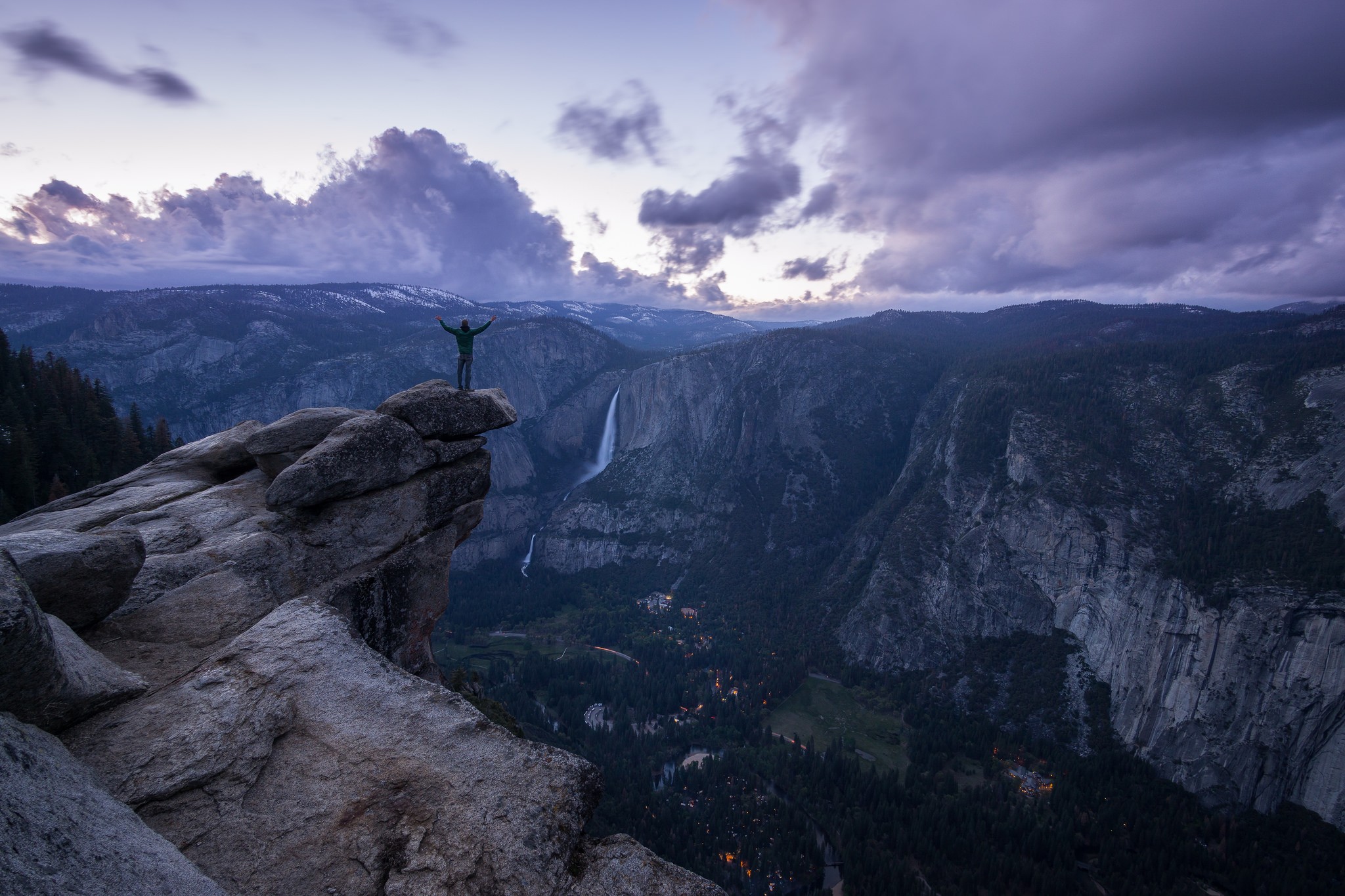 Man on cliff overlooking Yosemite Falls at dusk HD Wallpaper