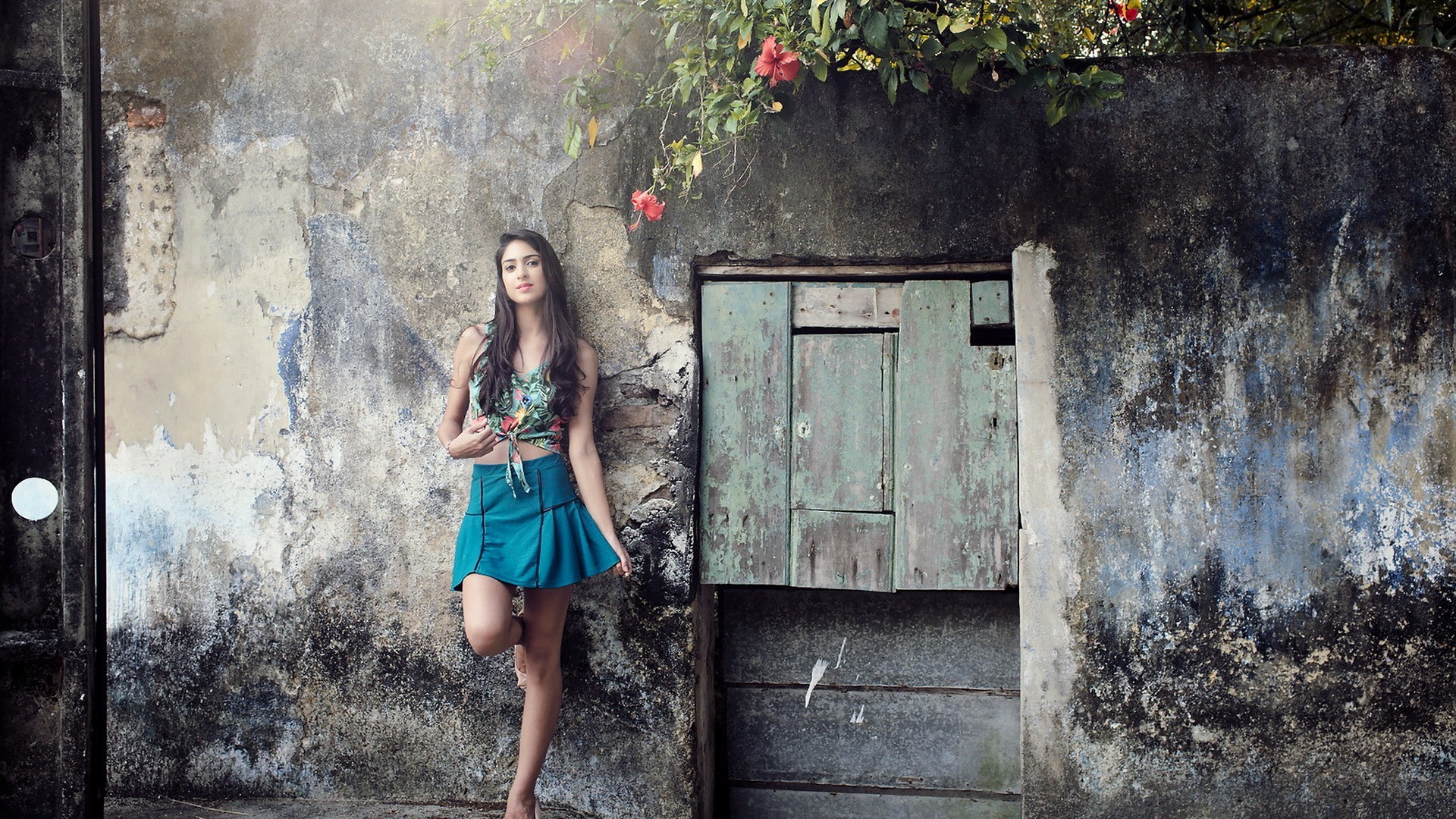 Woman in skirt leaning against a weathered wall HD Wallpaper
