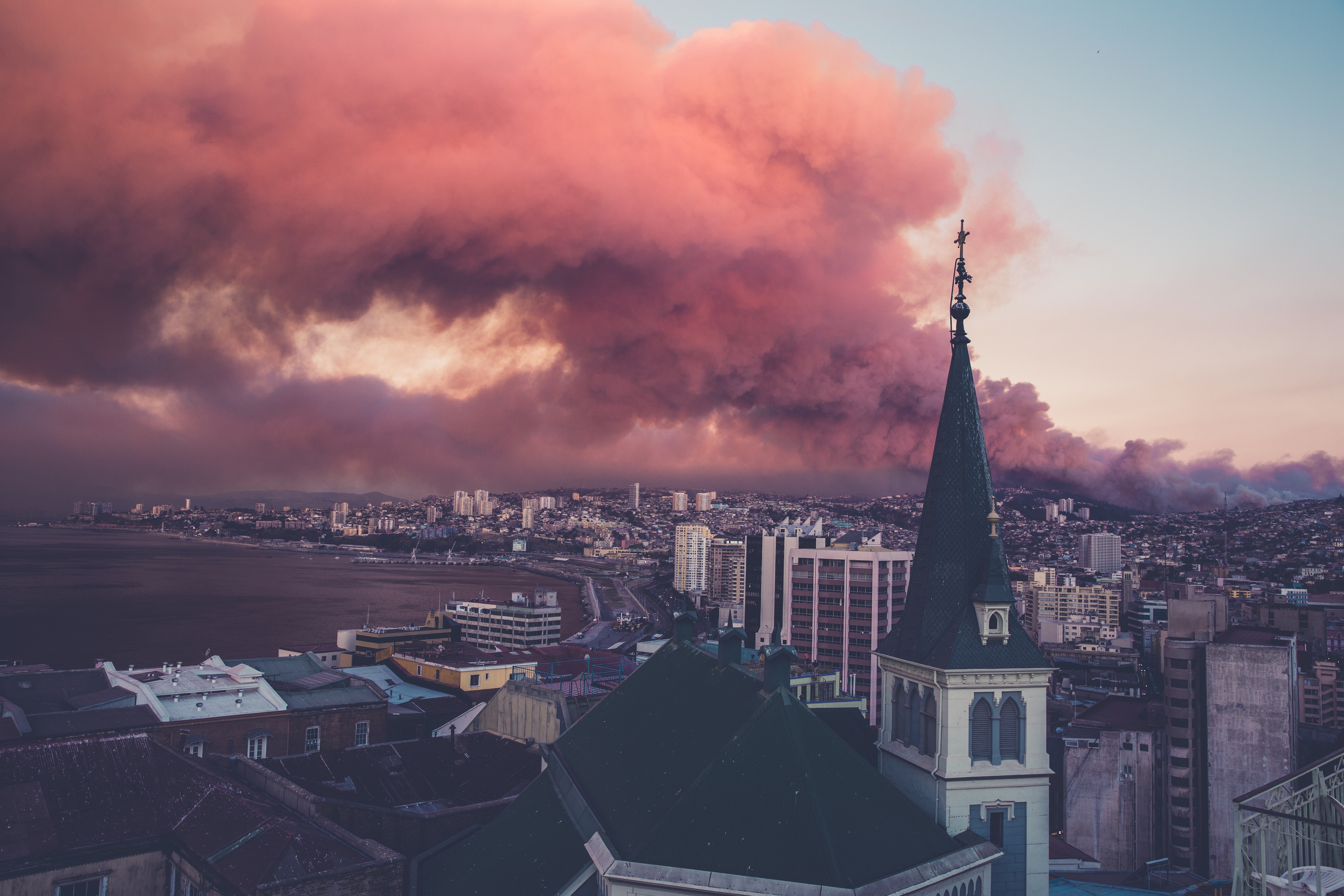 City skyline with smoke and church spire HD Wallpaper