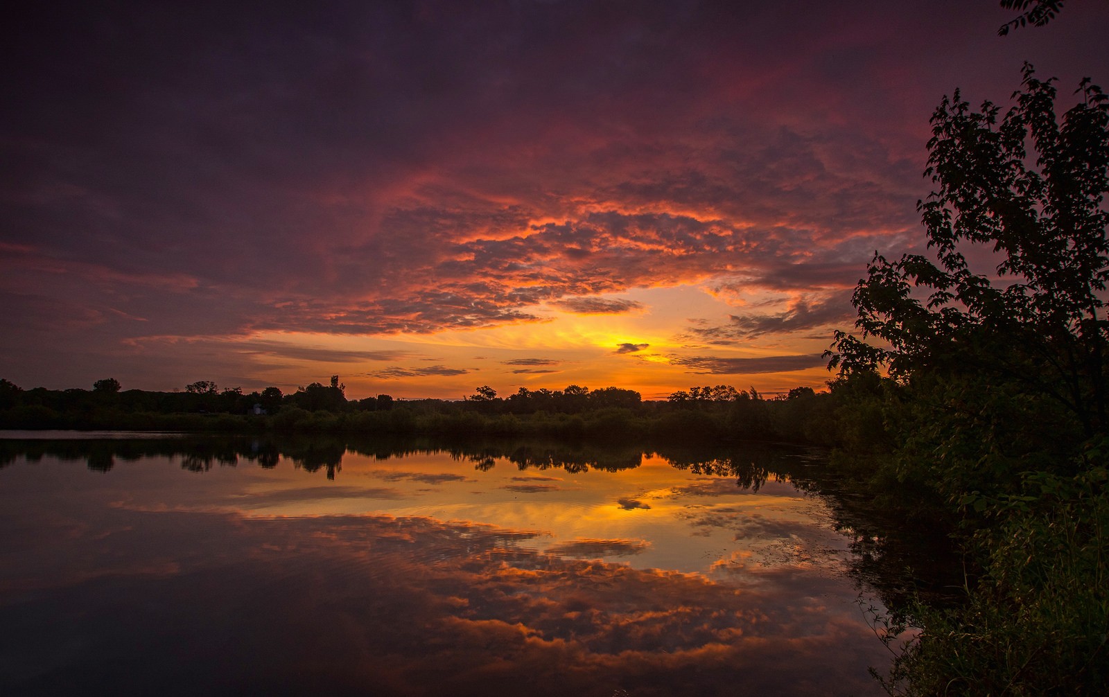 Sunset over a lake with colorful clouds and reflections HD Wallpaper