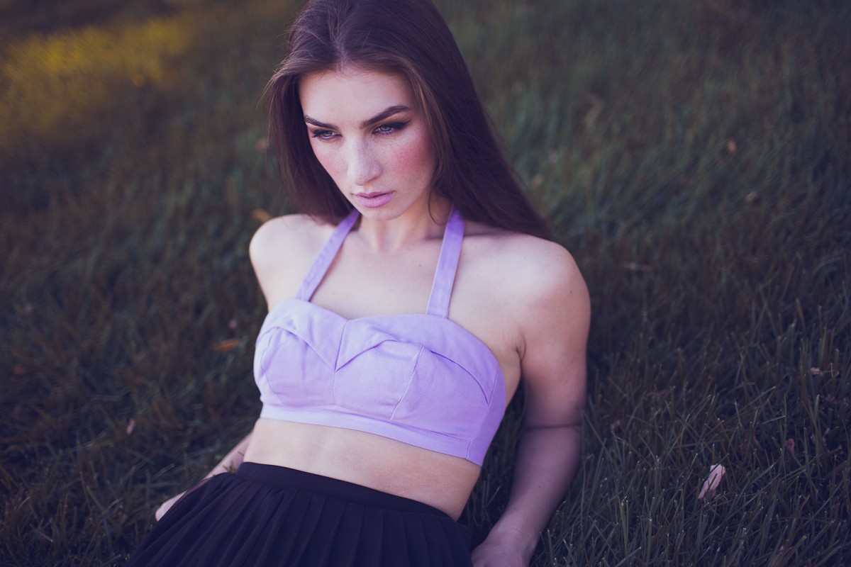Woman in a purple top and black skirt lying on grass HD Wallpaper