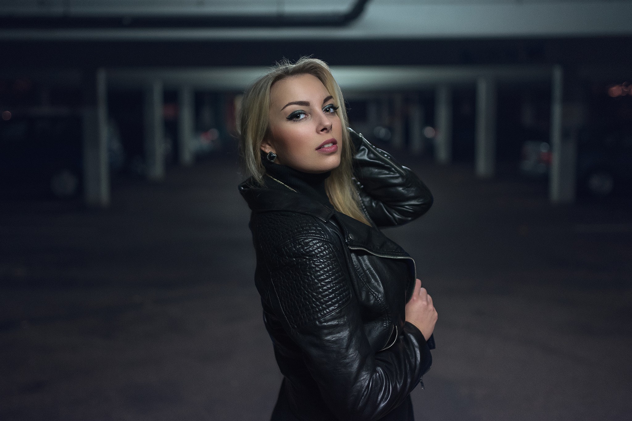 Blonde woman in leather jacket in parking garage HD Wallpaper