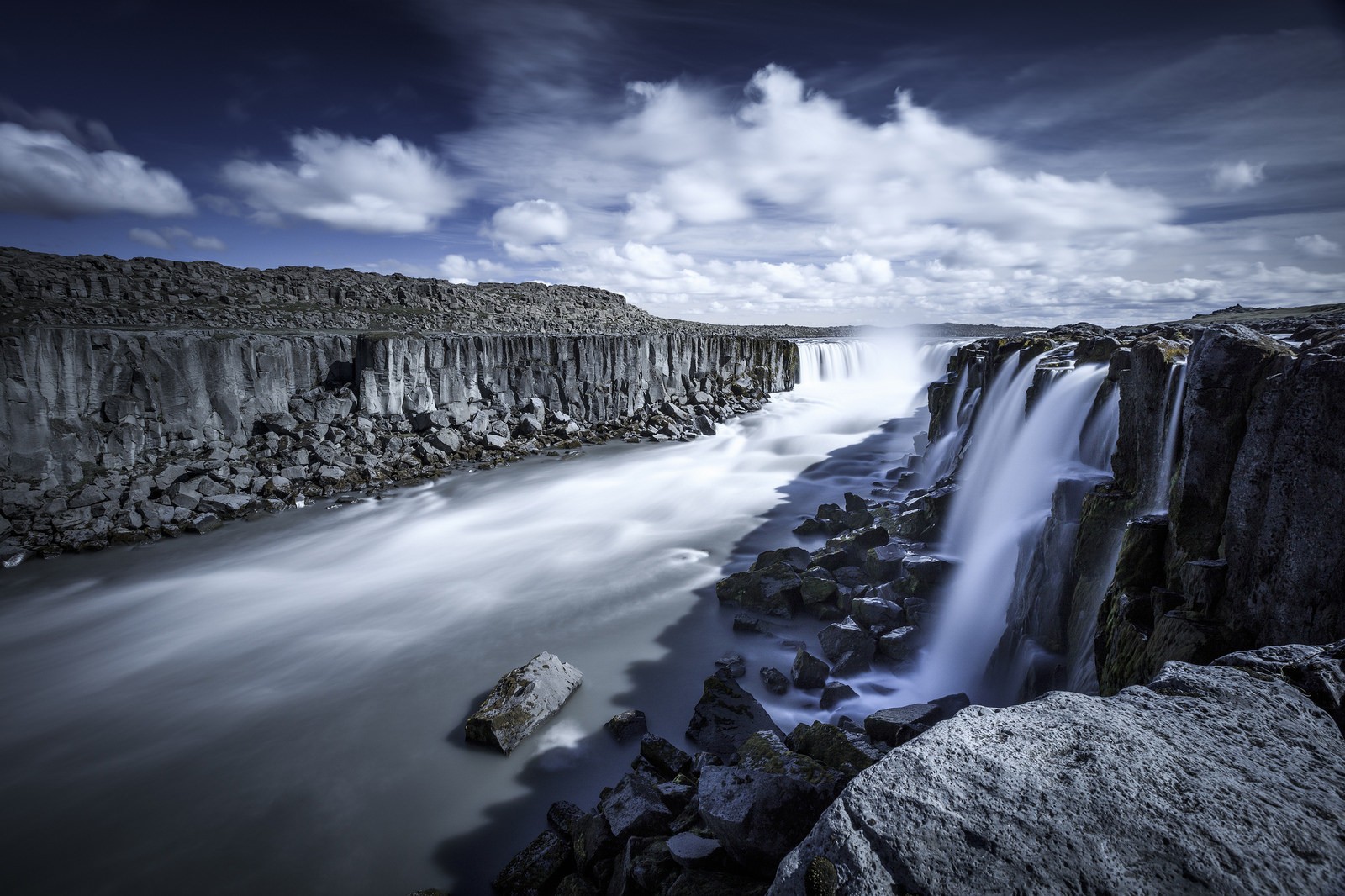 Waterfall in a rocky canyon under a cloudy sky HD Wallpaper