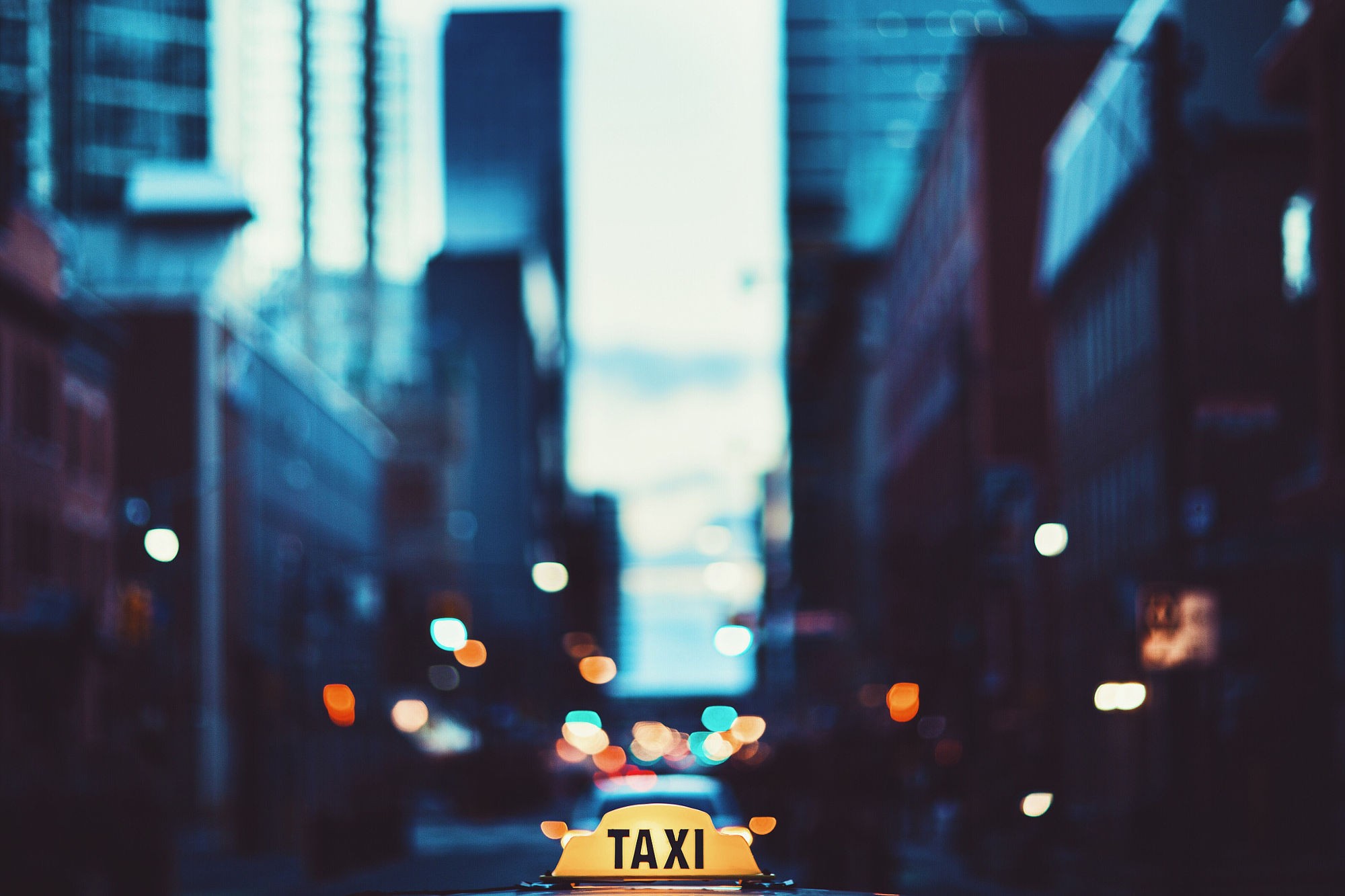 Taxi sign in a bokeh city street at night HD Wallpaper