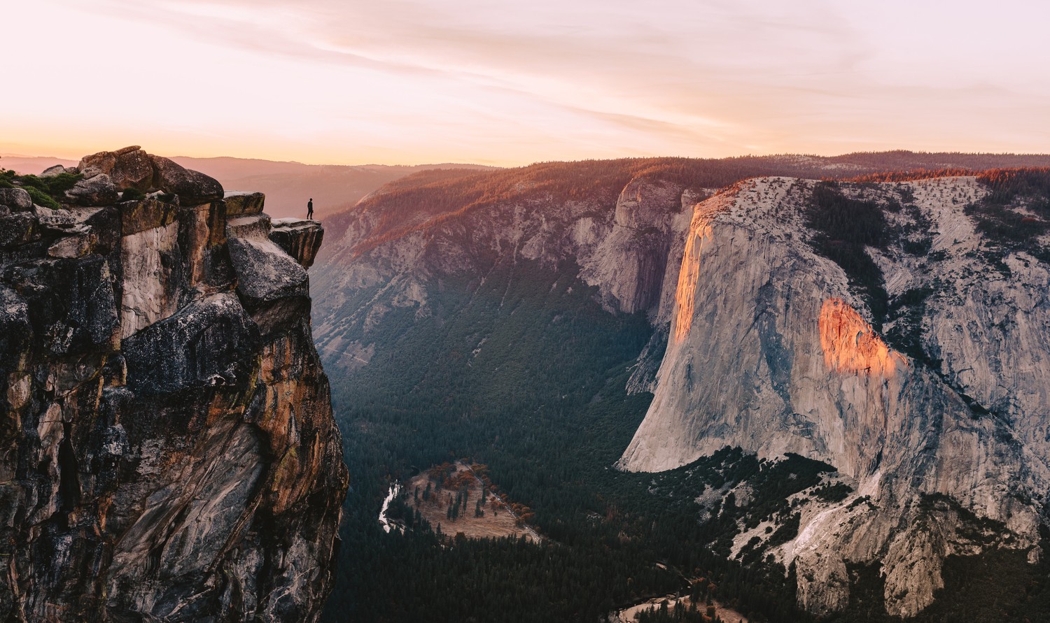 Man standing on a cliff overlooking Yosemite Valley at sunset HD Wallpaper