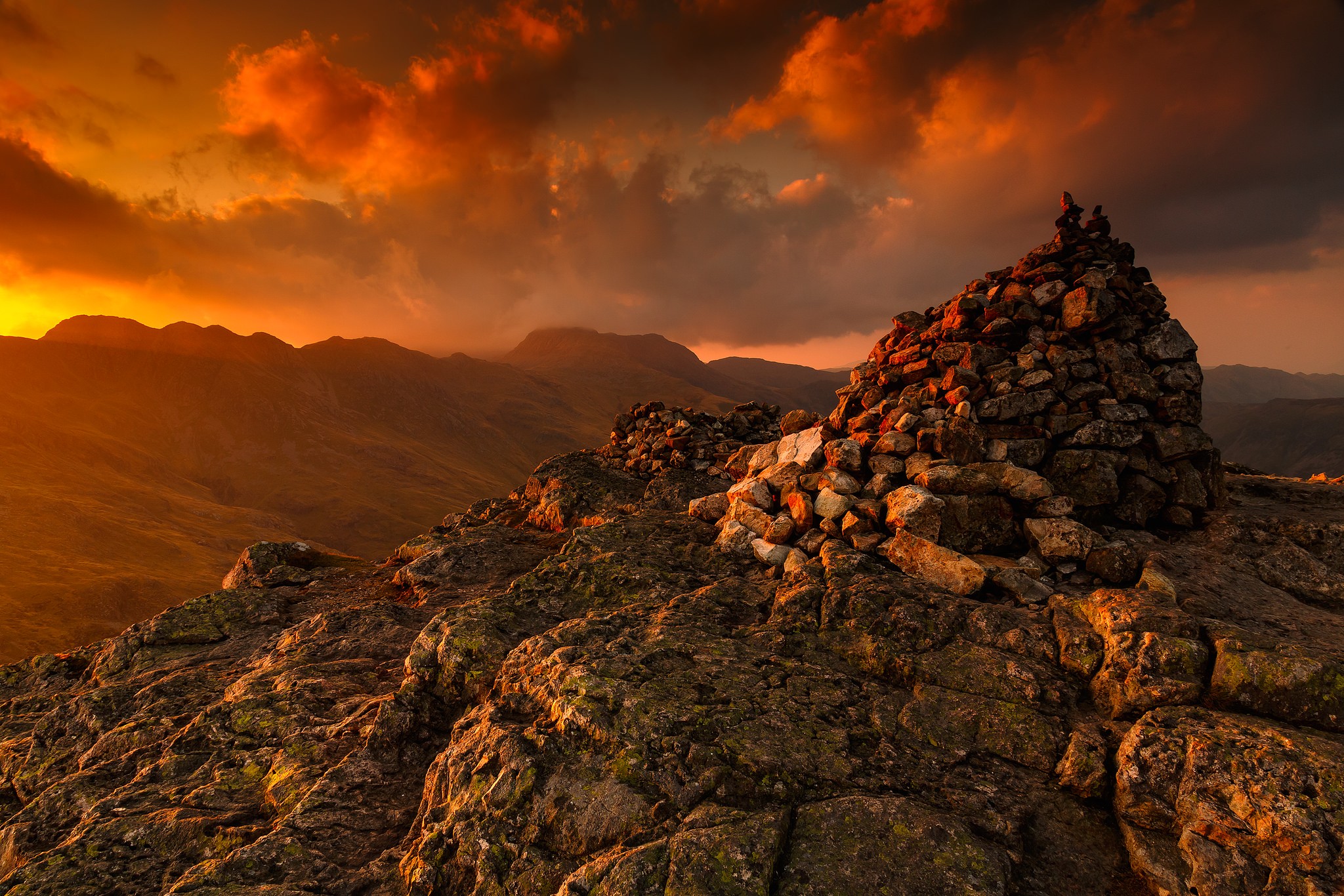 Cairn on a rocky mountain peak at sunset HD Wallpaper