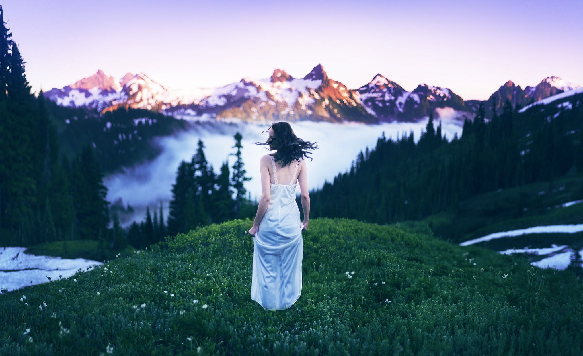 Woman in white dress on grassy hill with mountains HD Wallpaper