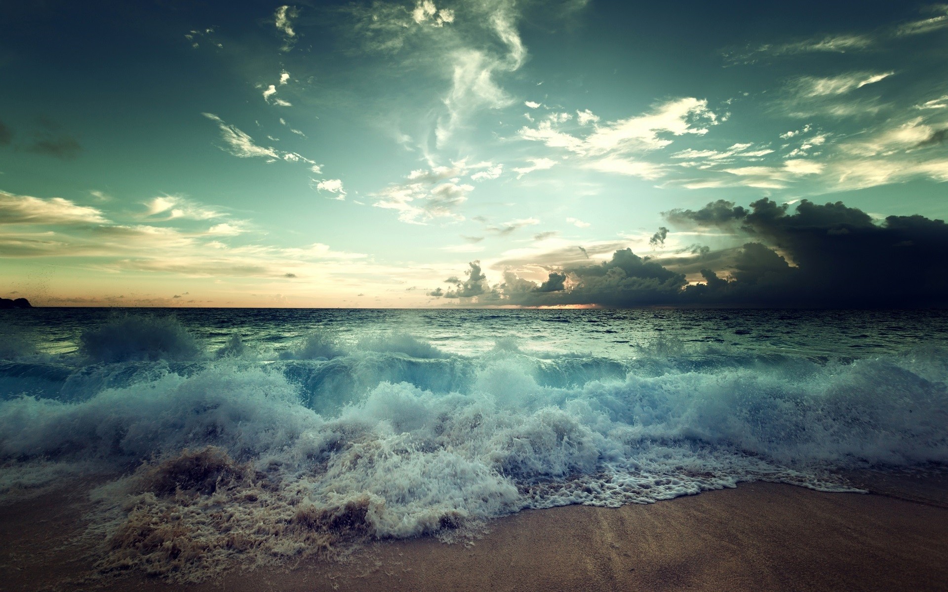 Waves crashing on a beach under a cloudy sky HD Wallpaper