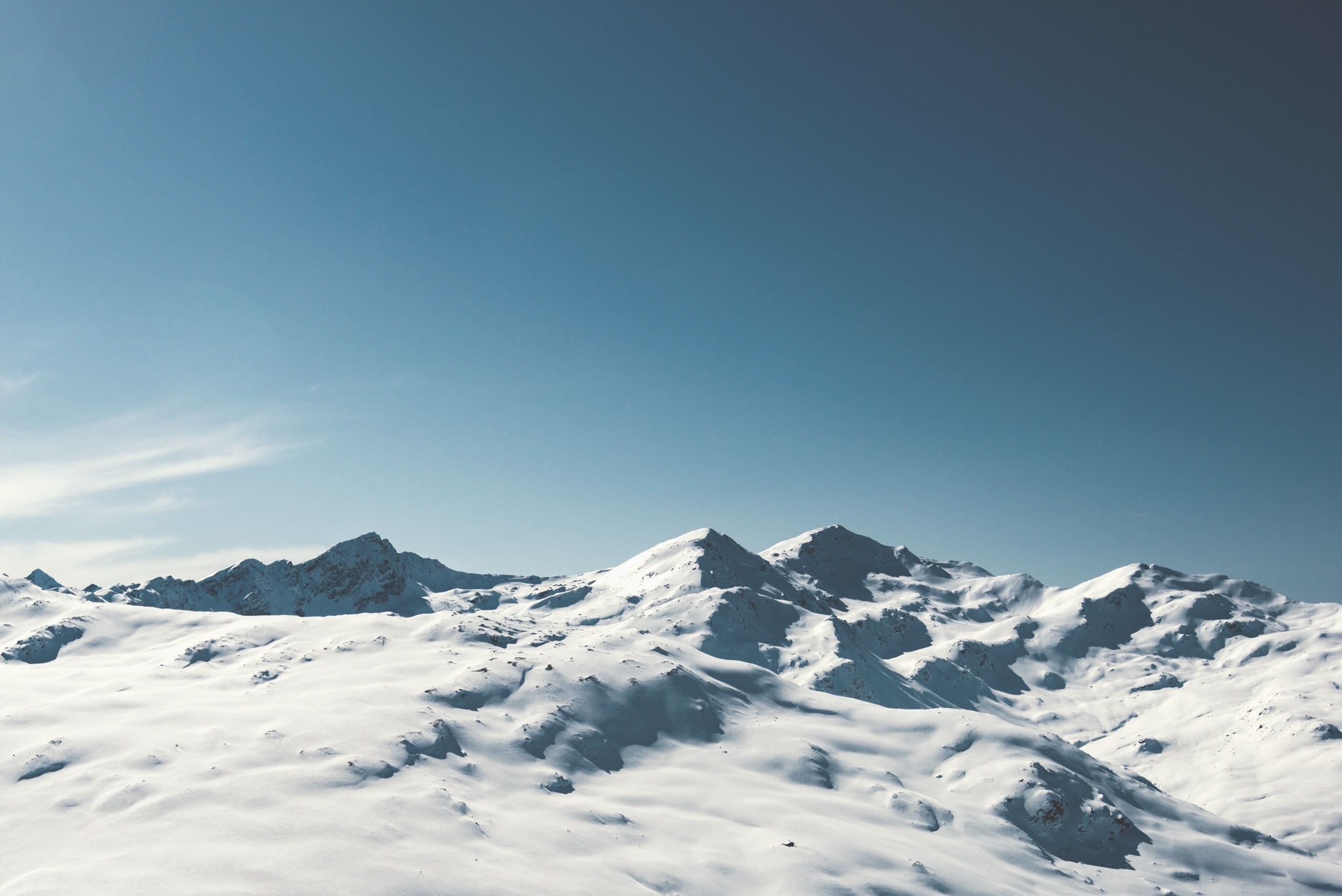 Snowy mountains under a clear blue sky HD Wallpaper