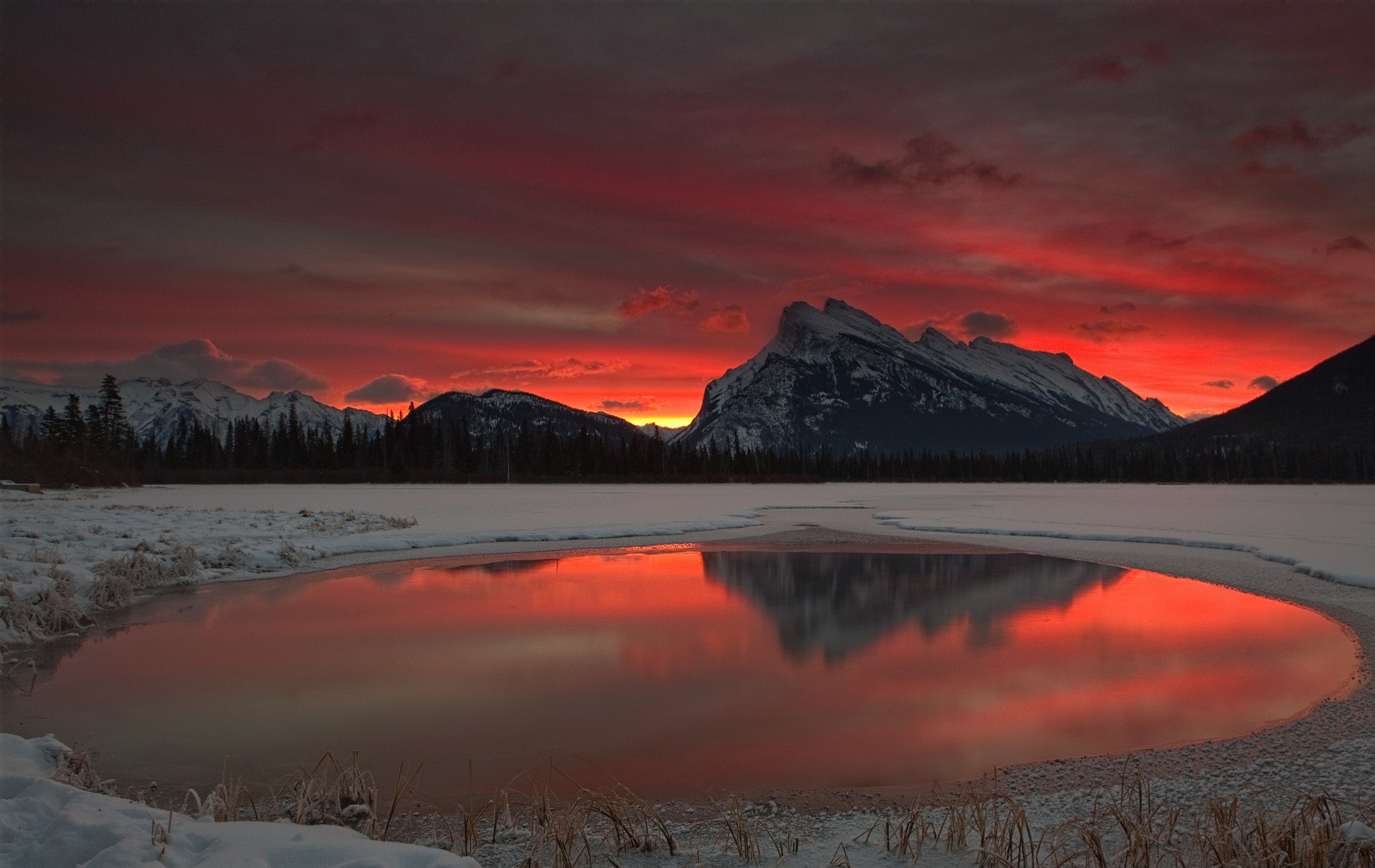 Snowy mountains reflected in a lake at sunset HD Wallpaper