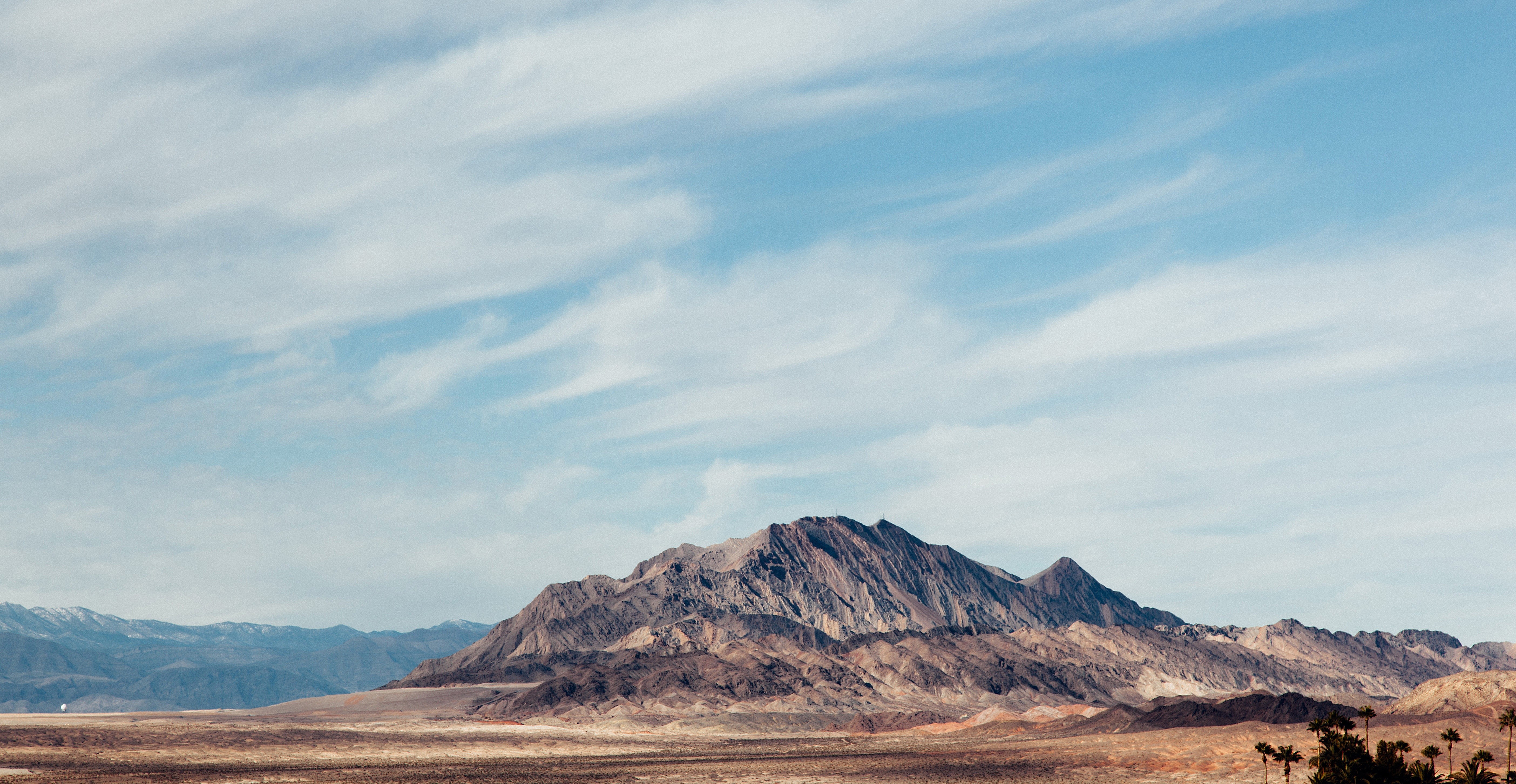 Desert mountains under a cloudy sky HD Wallpaper