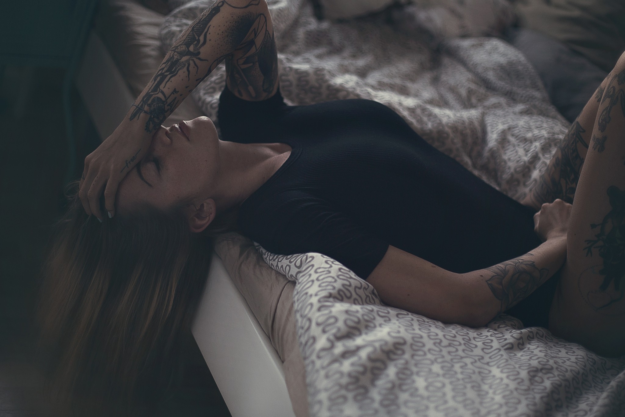 Woman with tattoos lying in bed HD Wallpaper