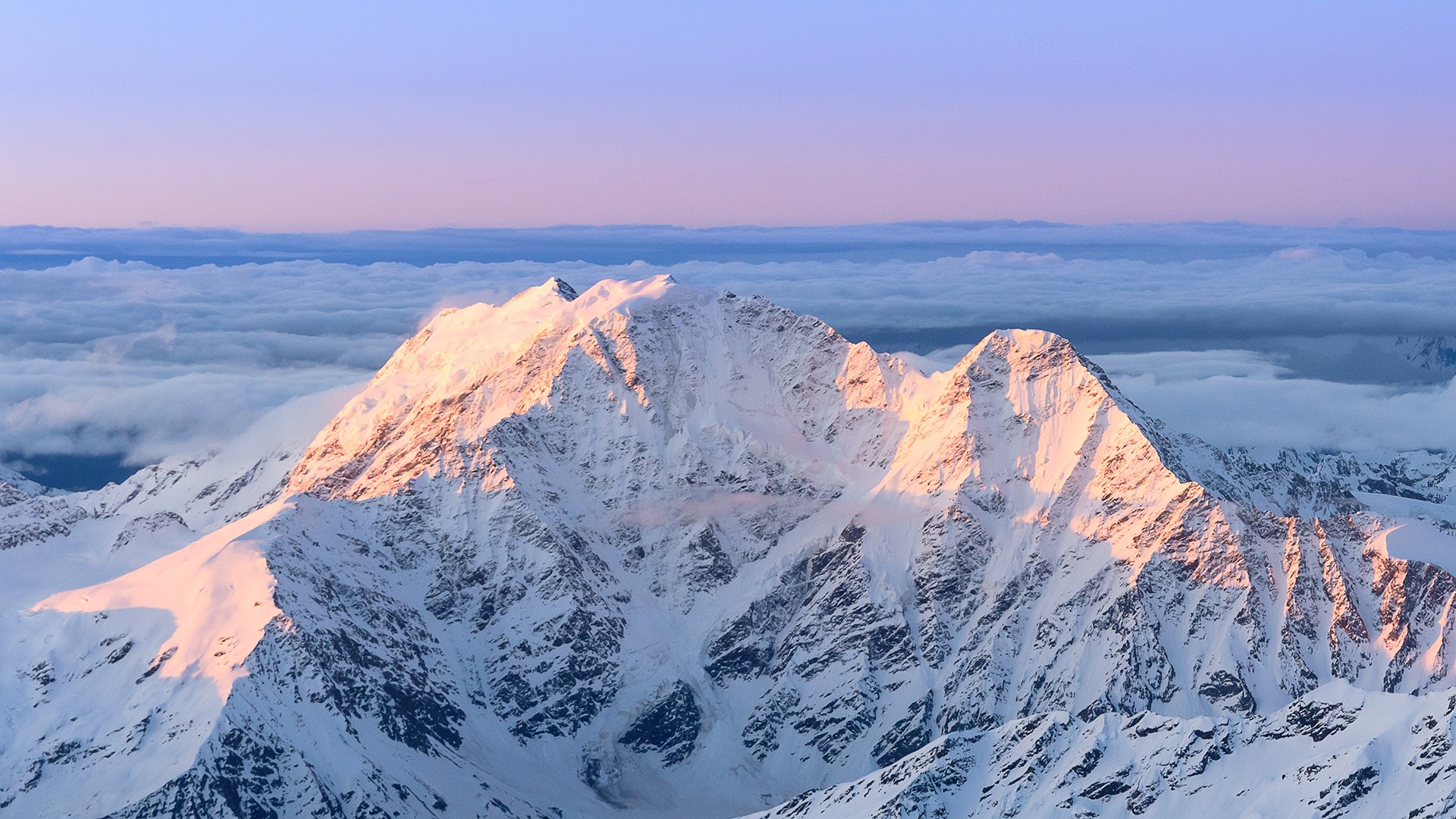 Snow-covered mountains at sunrise above clouds HD Wallpaper