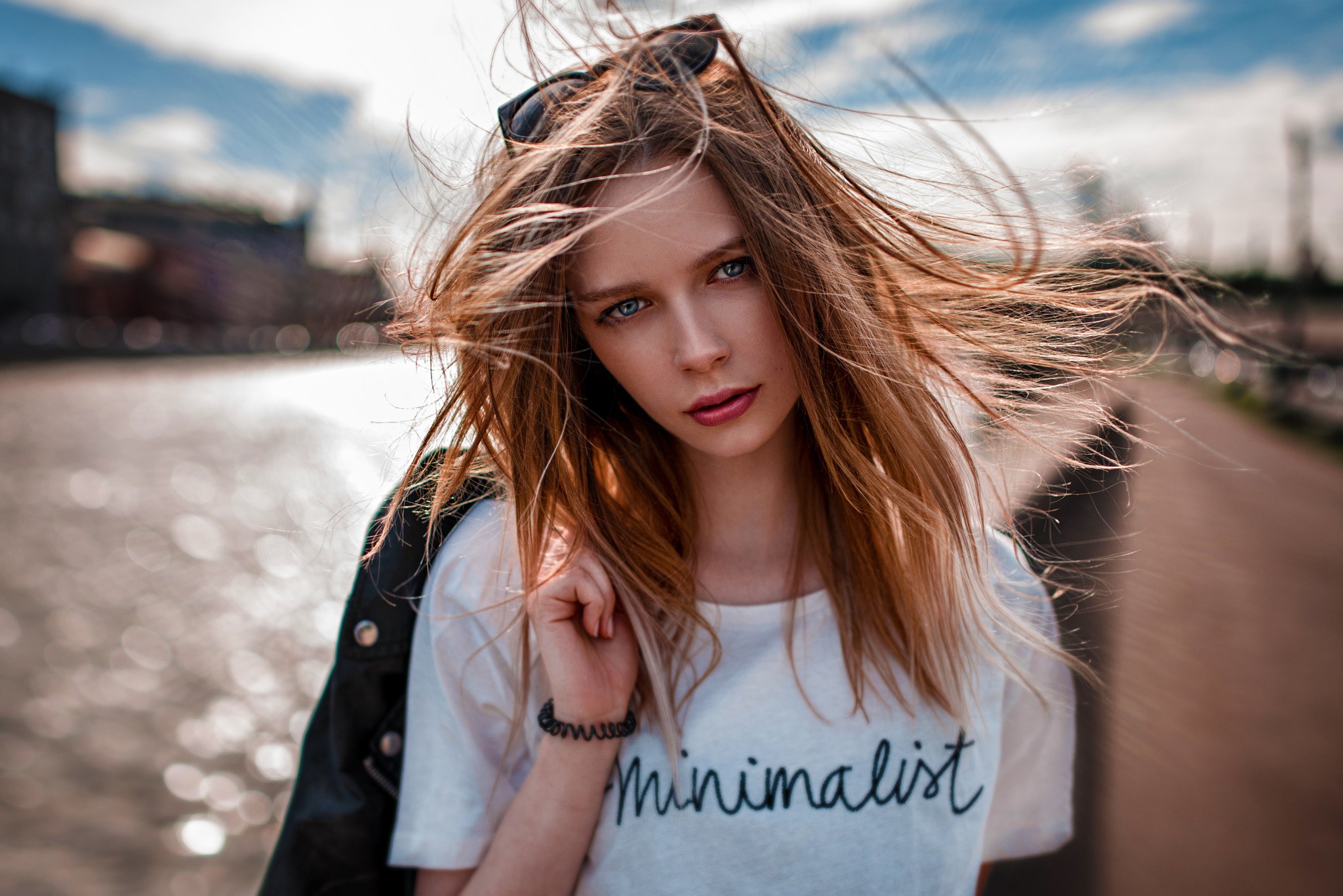 Woman with windblown hair in an urban setting HD Wallpaper