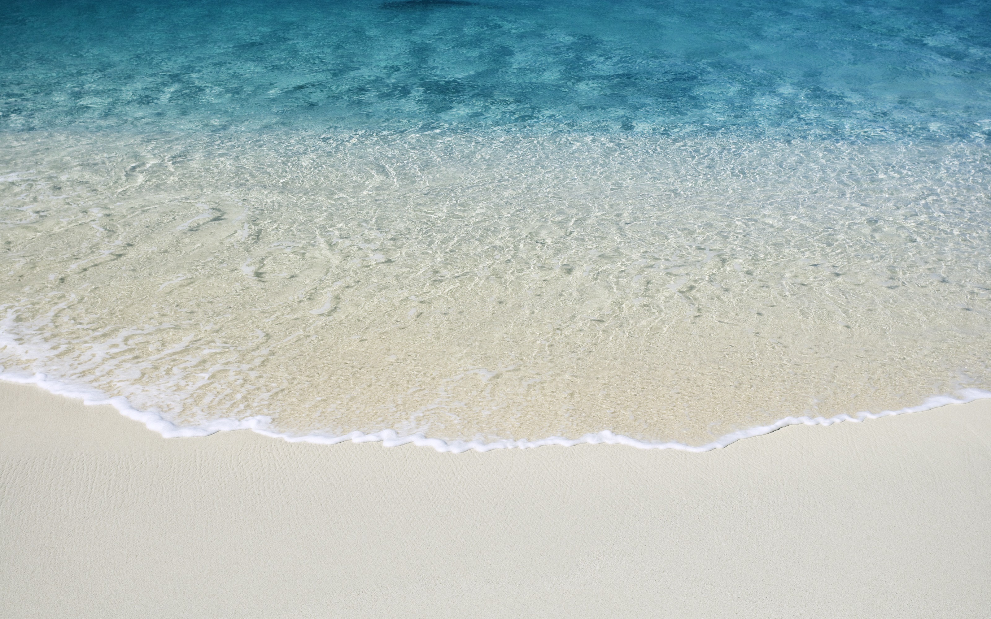 Clear blue sea waves washing onto a white sand beach HD Wallpaper