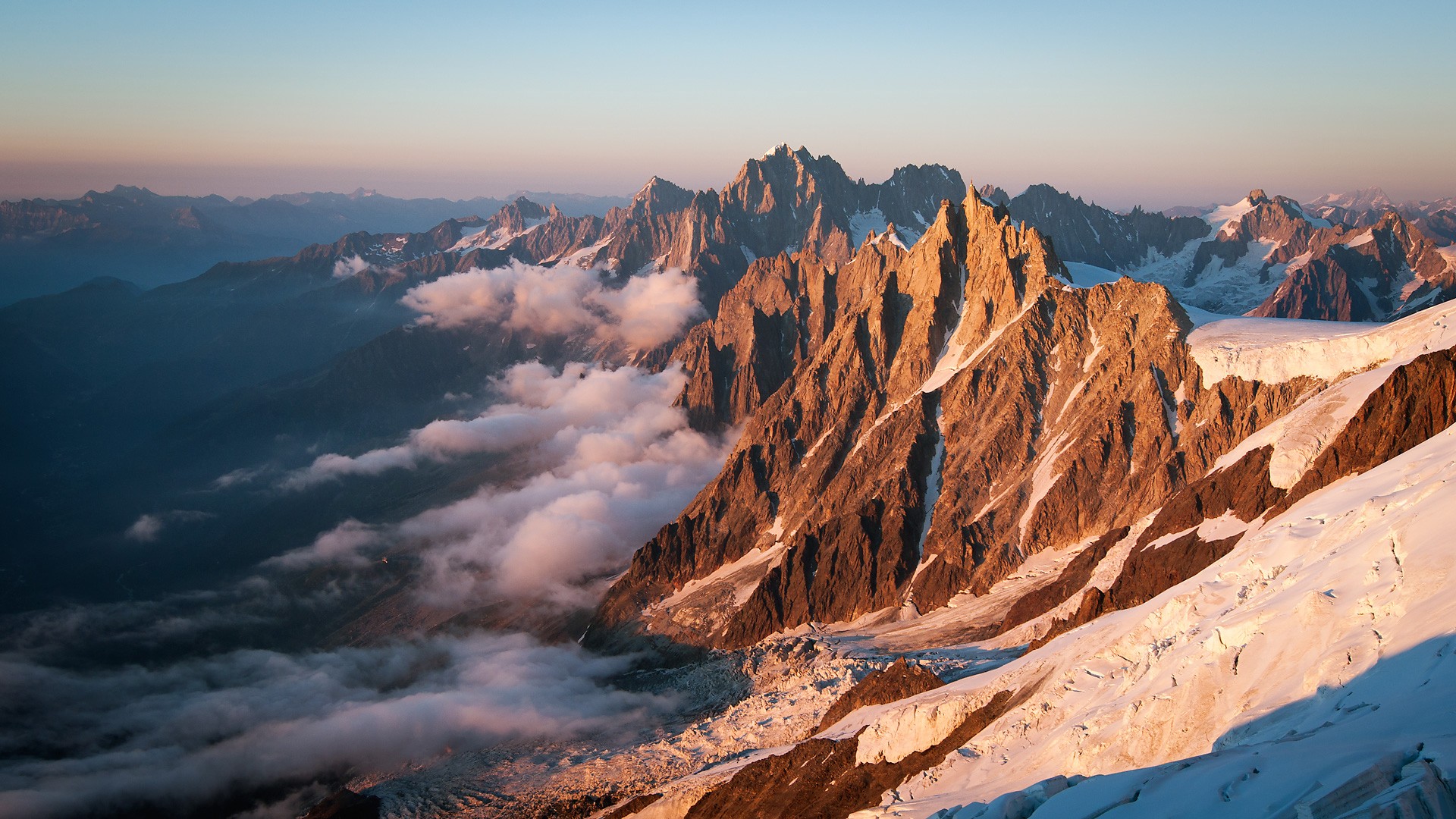 Sunrise over jagged mountain peaks with clouds HD Wallpaper