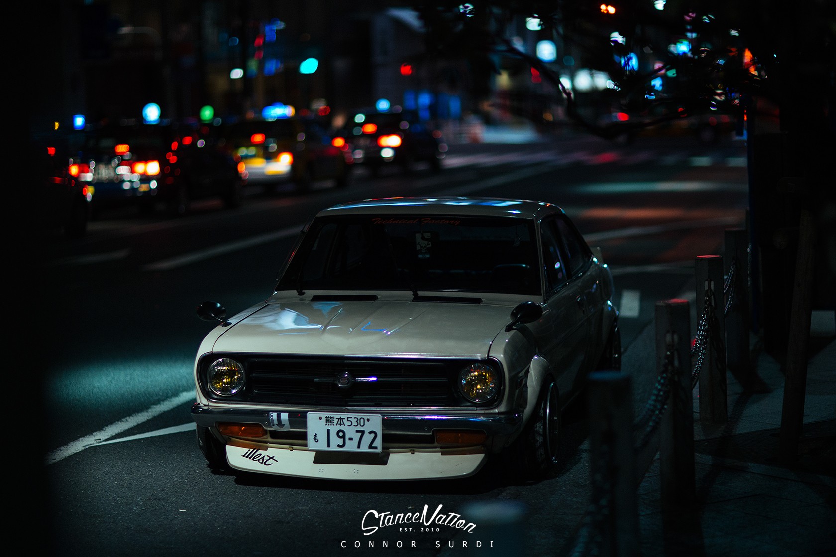 Datsun coupe parked on a city street at night HD Wallpaper