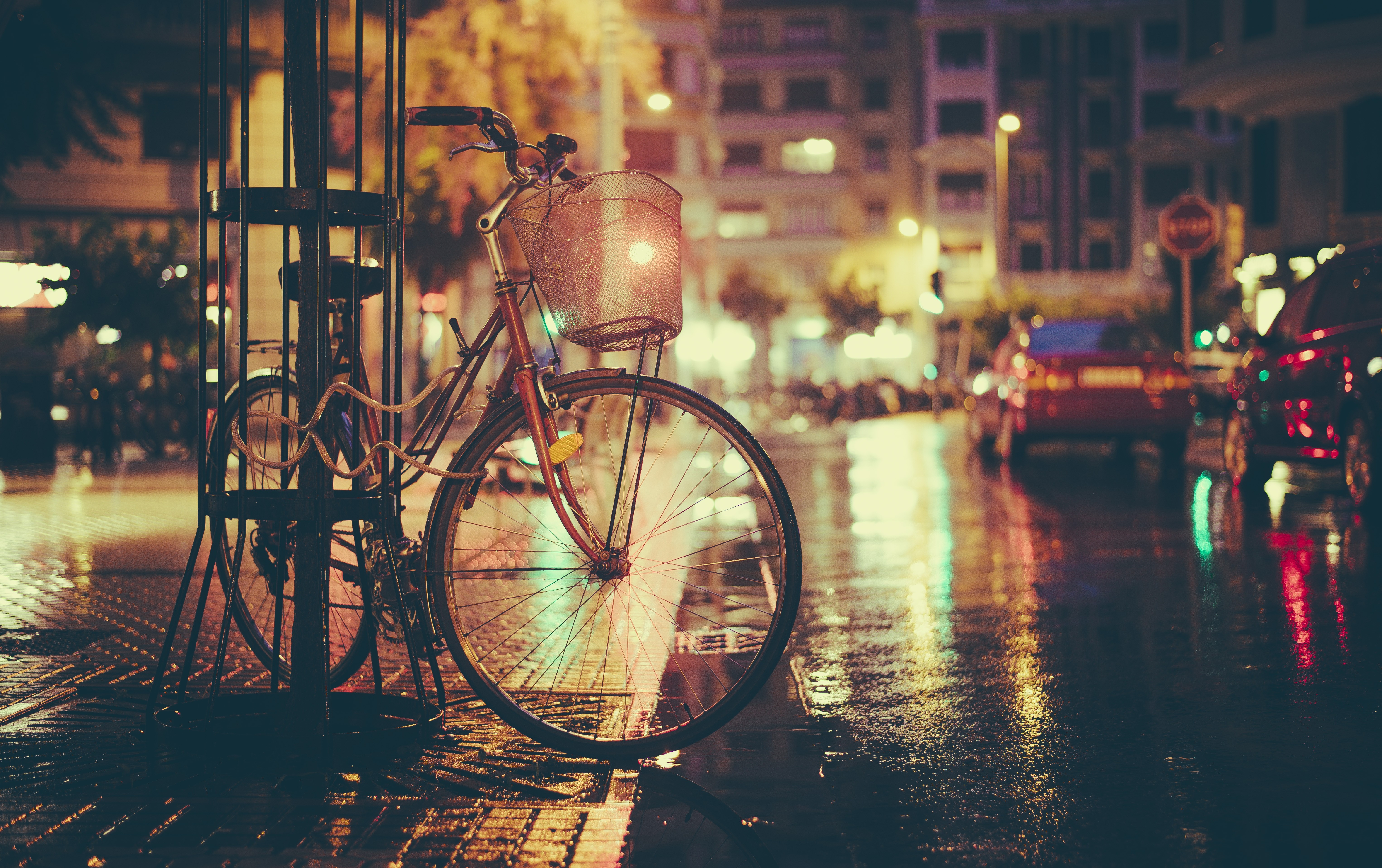 Bicycle parked on a wet city street at night HD Wallpaper