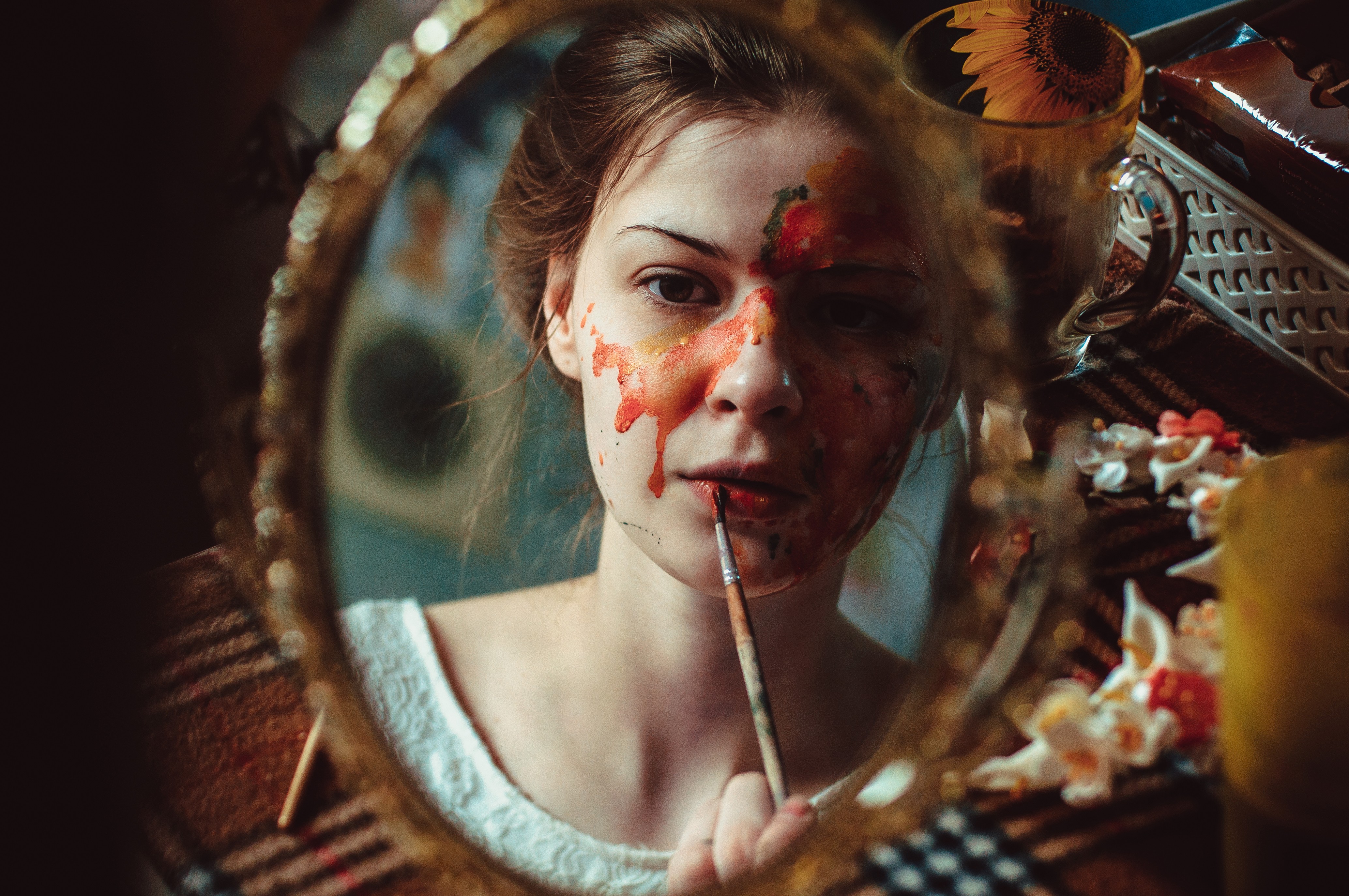 Woman with face paint applying lipstick in a mirror HD Wallpaper