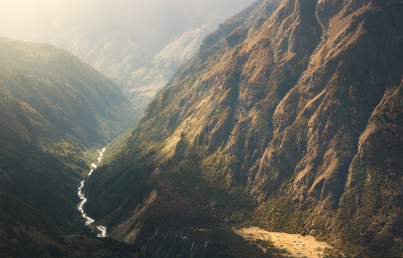 A winding river flows through a deep mountain valley HD Wallpaper