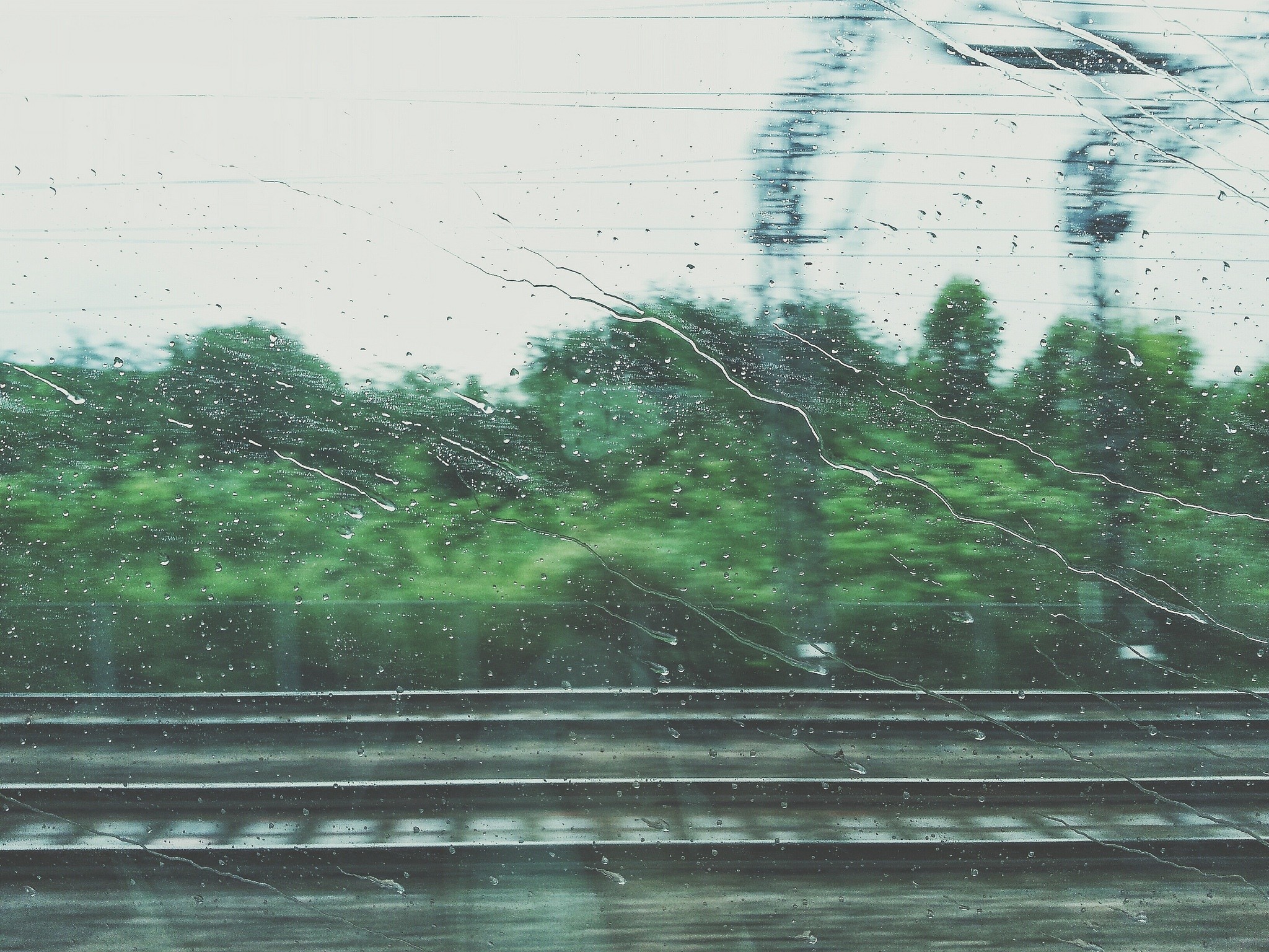 Train window with rain and railway tracks HD Wallpaper