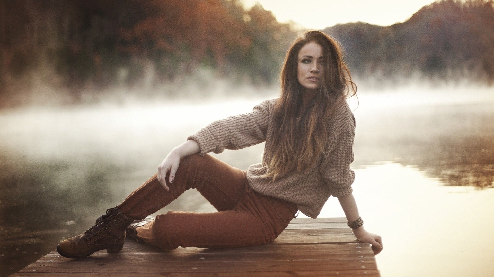 Woman sitting on a dock by a misty lake HD Wallpaper