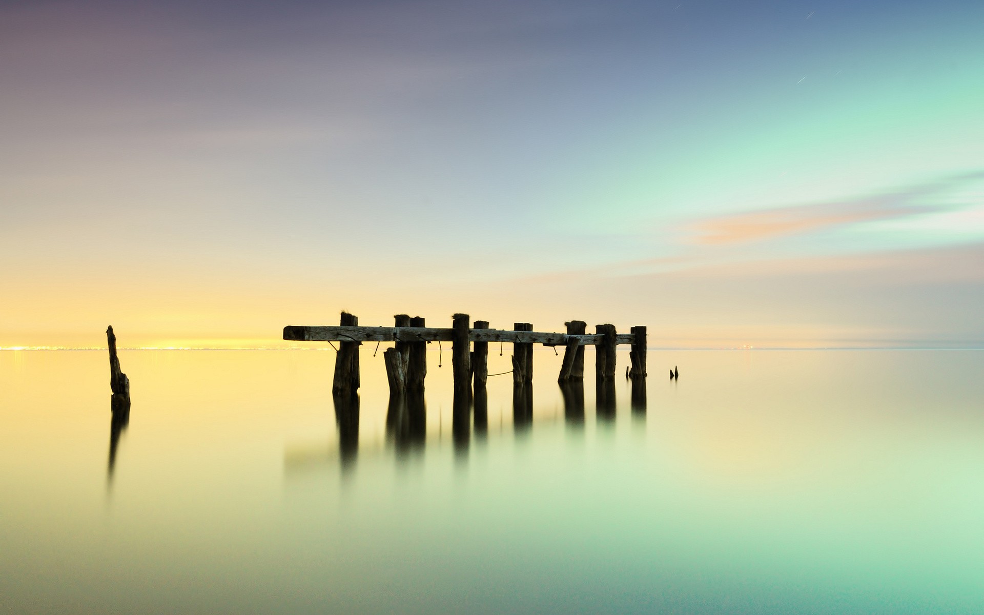 Old wooden pier on a calm sea at sunset HD Wallpaper