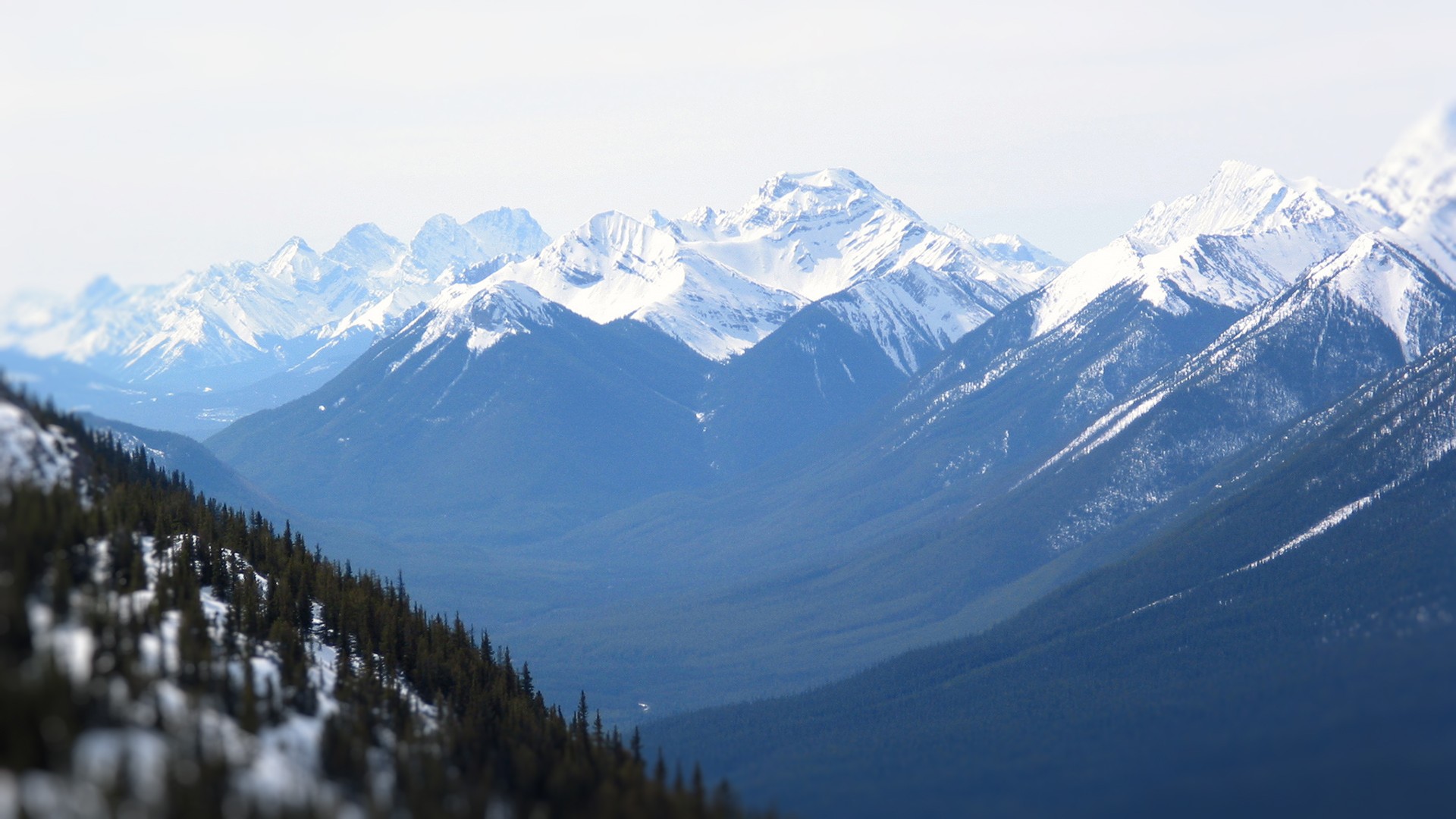 Snow-covered mountains under a bright sky HD Wallpaper