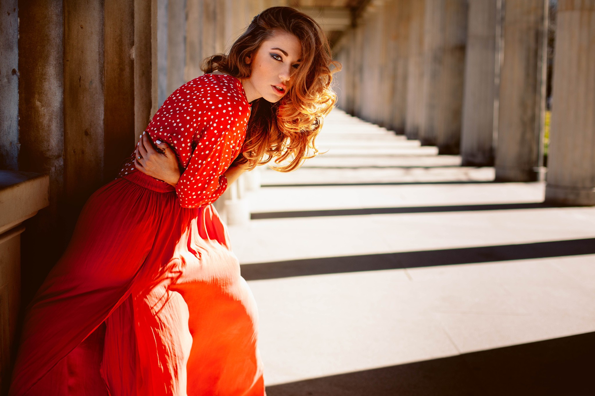 Woman in red dress posing by columns HD Wallpaper