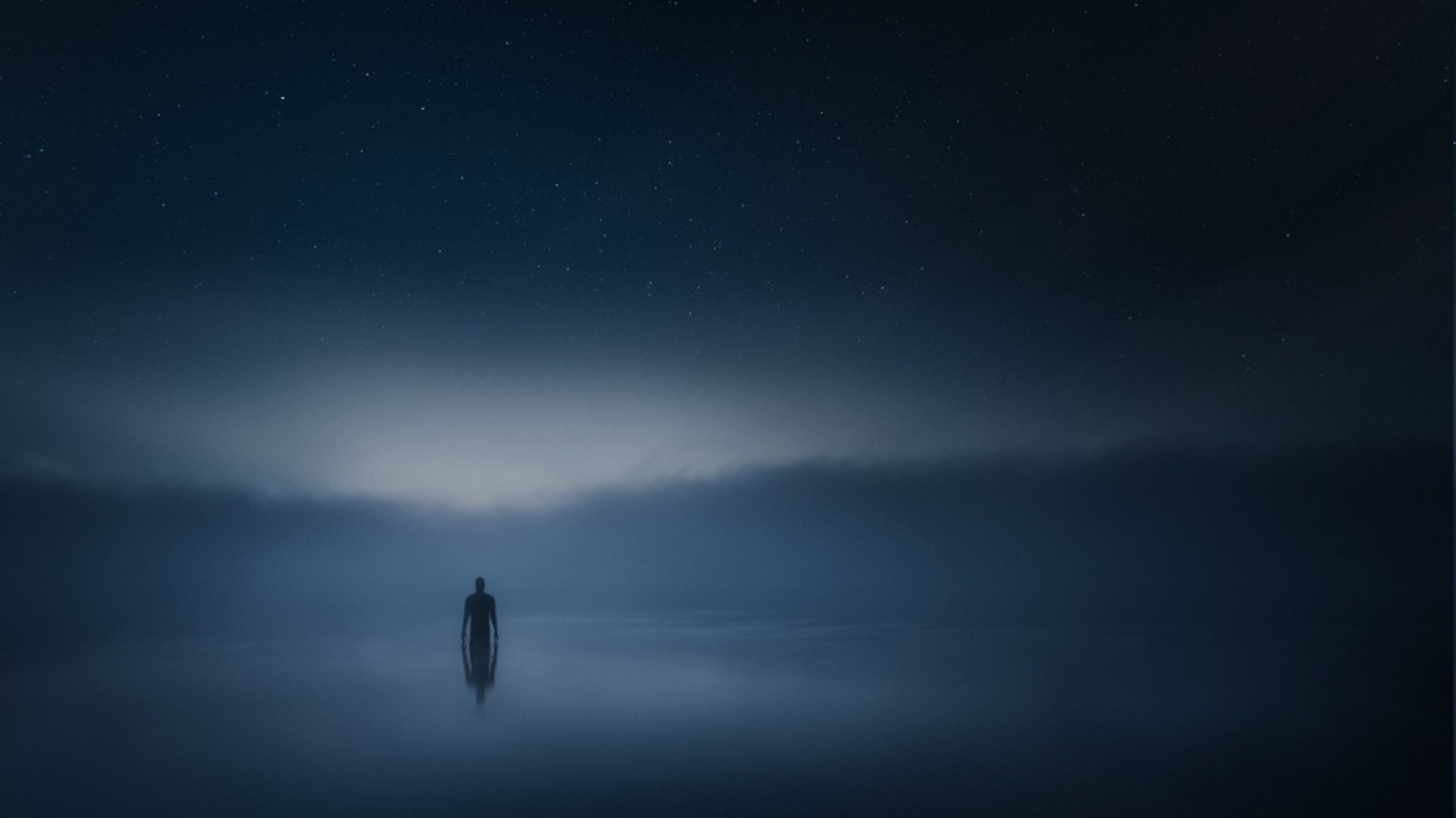 Silhouette of a person in a misty river under the stars HD Wallpaper